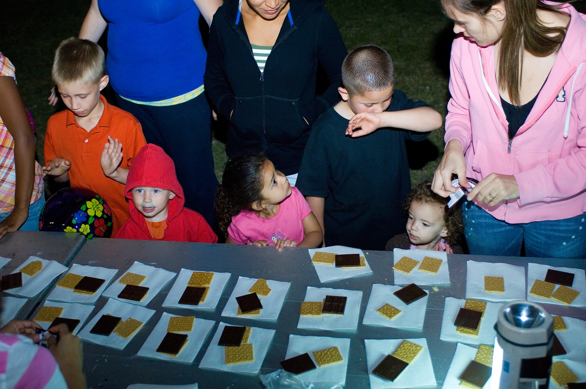 Children line up during the Family Camp Out to receive the graham cracker and chocolate parts of their s'mores at Luke Air Force Base, Ariz., April 9. One hundred and fifty people, active duty, retired and dependents, signed up for the event. (U.S. Air Force Photo by Staff Sgt. Jason Colbert)
