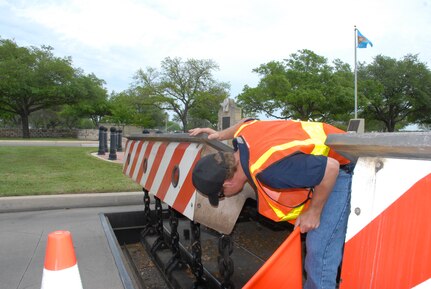 Doug Hyland, a maintenance contractor with Stobil Enterprises, inspects Randolph Air Force Base's in-ground denial barriers on Harmon Drive near the main gate April 12. (U.S. Air Force photo by Senior Airman Katie Hickerson)