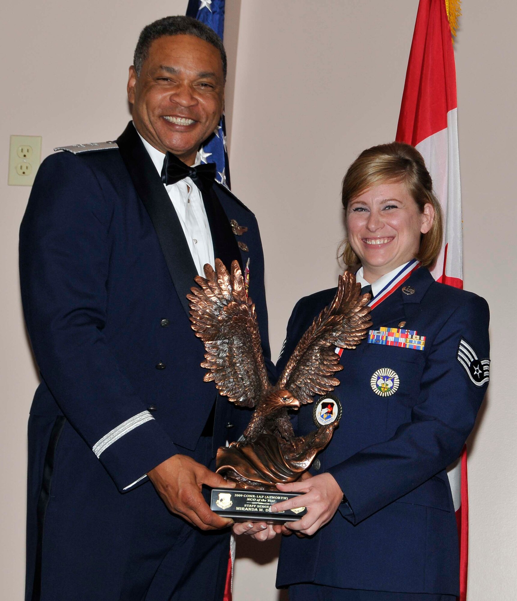 Air Forces Northern commander Maj. Gen. Garry C. Dean (left) presents the 1st Air Force Noncommissioned Officer of the Year trophy to Staff Sgt. Miranda M. Demers at the organization’s 2010 Annual Awards Banquet.  Demers, a member of the 722nd Air Control Squadron in North Bay, Ontario, Canada, earned the award for her implementation of the Air Force Medical Data Management System at a geographically separated unit.