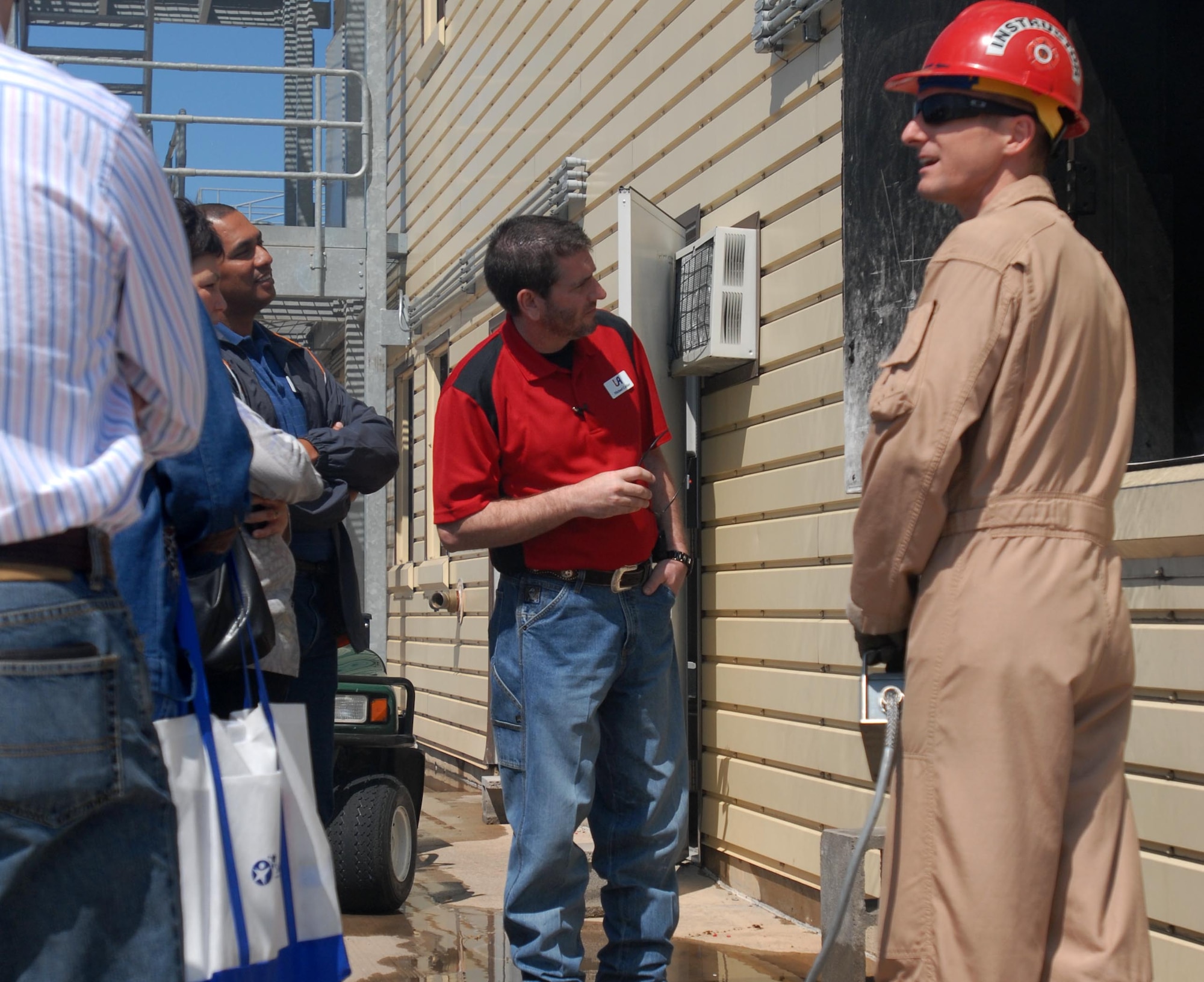 GOODFELLOW AIR FORCE BASE, Texas -- Staff Sgt. Michael Ott, 312th Training Squadron fire course instructor explains to more than 30 Leadership San Angelo members how firefighters train. With controller in hand, Sergeant Ott can control the rate and amount of smoke and fire, to give students a realistic scenario when attempting to put out room fires. The group is part of the Chamber of Commerce program to develop and hone the skills of future civic leaders. (U.S. Air Force photo/ Senior Airman Tong Duong)