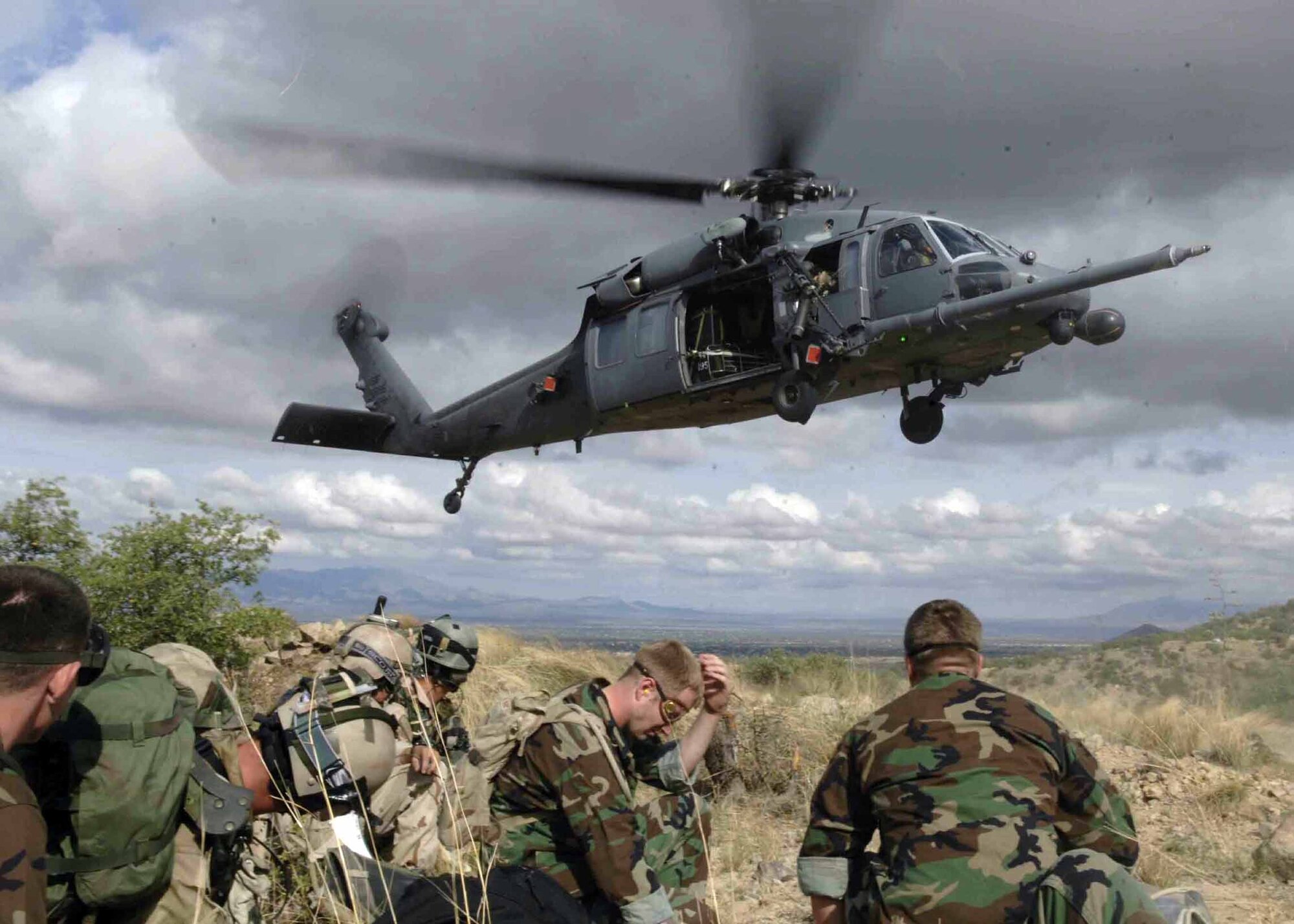 Pararescuemen and simulated mass casualty survivors take cover as a HH-60G Pavehawk lands July 27, 2006, as part of Exercise Angel Thunder. The survivors were flown to Davis-Monthan Air Force Base, Ariz., to a simulated level 2/3 medical facility. Angel Thunder 2010 kicked off April 13, 2010. (U.S. Air Force photo/Senior Airman Christina D. Ponte)