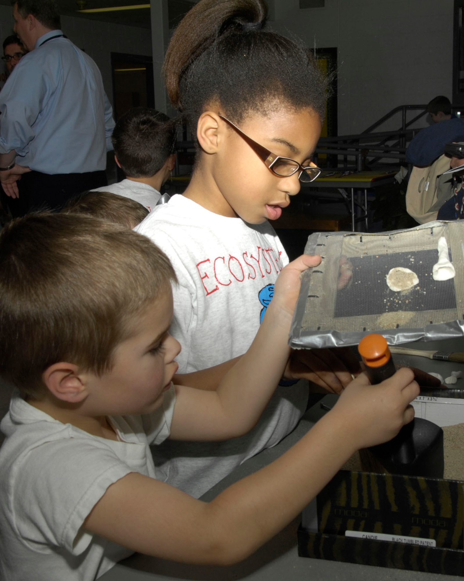 HANSCOM AIR FORCE BASE, Mass. - Jameya Jenkins shows Trey Davis about fossils during the Hanscom Primary School K-4 Science Share Fair on April 13. Students worked with volunteer coaches from the base to learn and discover new science topics through lessons, books and experiments. (U.S. Air Force photo by Linda LaBonte Britt)