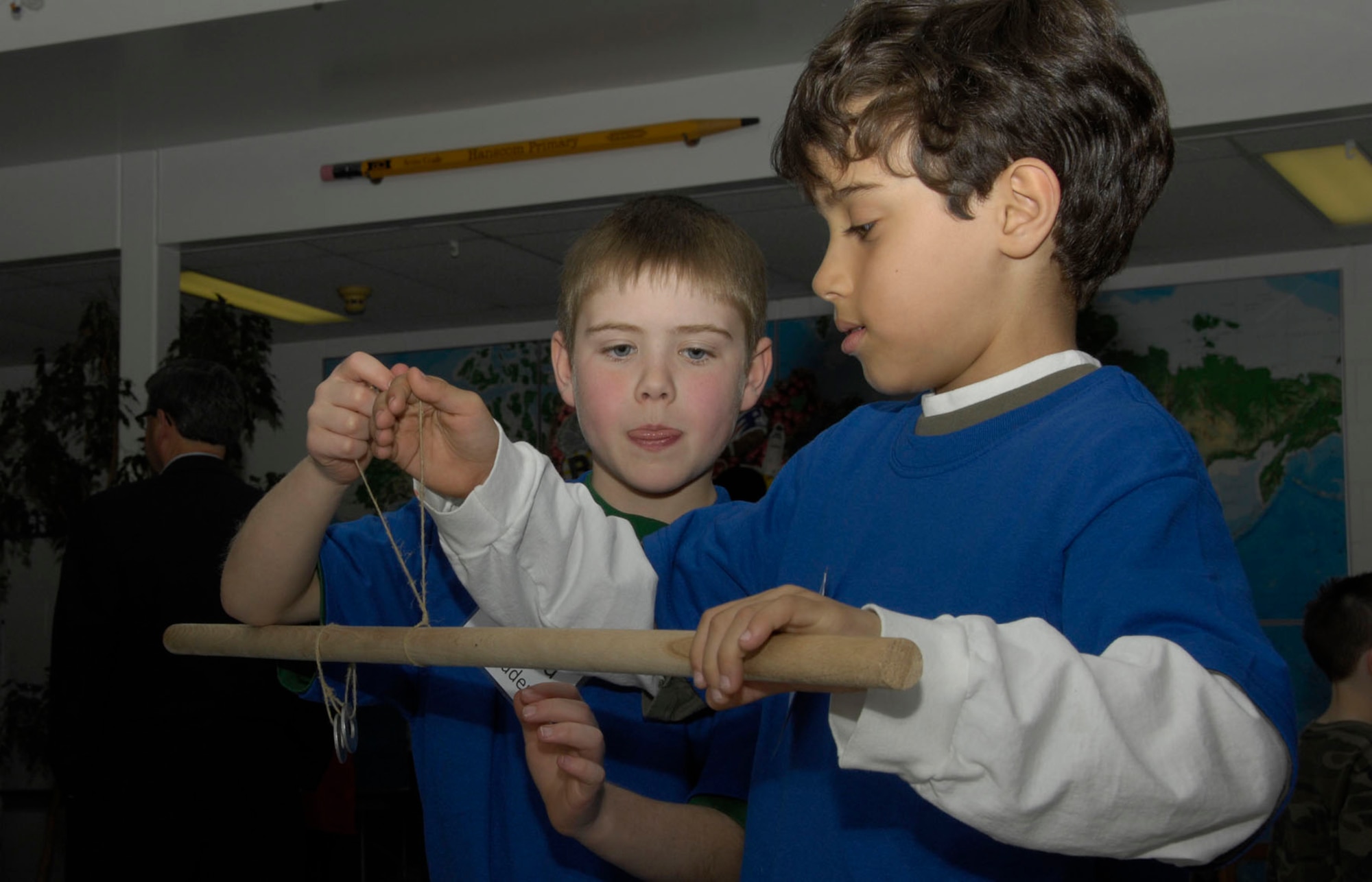 HANSCOM AIR FORCE BASE, Mass. - Using only a wooden stick, a measuring tape, metal washers, some twine and the scientific method, students Todd Davis (l) and Adam Maagol discover the scientific principle of torque during the Hanscom Primary School K-4 Science Share Fair on April 13. Students worked with volunteer coaches from the base to learn and discover new science topics through lessons, books and experiments. (U.S. Air Force photo by Linda LaBonte Britt)