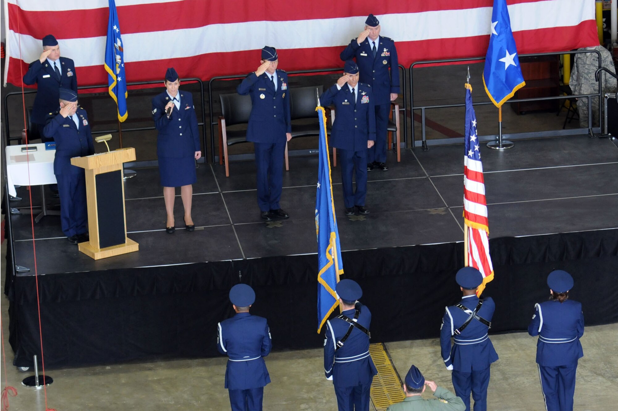 YOUNGSTOWN AIR RESERVE STATION, Ohio -- Air Force Reserve Megan Tomkins sings the national anthem as the narrator and the official party salute the colors during a wing change of command ceremony in a hangar here, April 11. Col. Fritz Linsenmeyer assumed command of the 910th Airlift Wing from Col. Karl McGregor during the event. Col. McGregor assumed command of the 452nd Air Mobility Wing at March Air Reserve Base, Calif., March 27. Col. Linsenmeyer's previous assignment was commander of the 916th Air Refueling Wing, an Air Force Reserve unit at Seymour Johnson Air Force Base, NC. As commander of the 910th, Col. Linsenmeyer is the leader of more than 1800 Citizen Airmen, Air Reserve Technicians and civil service employees and has operational control of 12 C-130H tactical cargo transport aircraft. U.S. Air Force photo by Tech. Sgt. Rick Lisum.