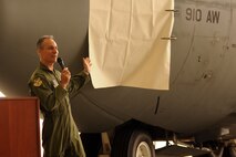 YOUNGSTOWN AIR RESERVE STATION, Ohio -- Air Force Reserve Col. Karl McGregor, commander of the 910th Airlift Wing, speaks to a group gathered to witness the unveiling of new nose art on a C-130H Hercules tactical cargo transport aircraft during a ceremony here, April 7. The nose art titled "Global Humanitarian Support" recognizes the humanitarian missions carried out by the Citizen Airmen and aircraft of the 910th over the last several years. These missions have included aerial spray relief in the aftermatch of several hurricanes, medical services, civil engineer work and airlift support to numerous locations around the world. U.S. Air Force photo by Mr. Eric White.