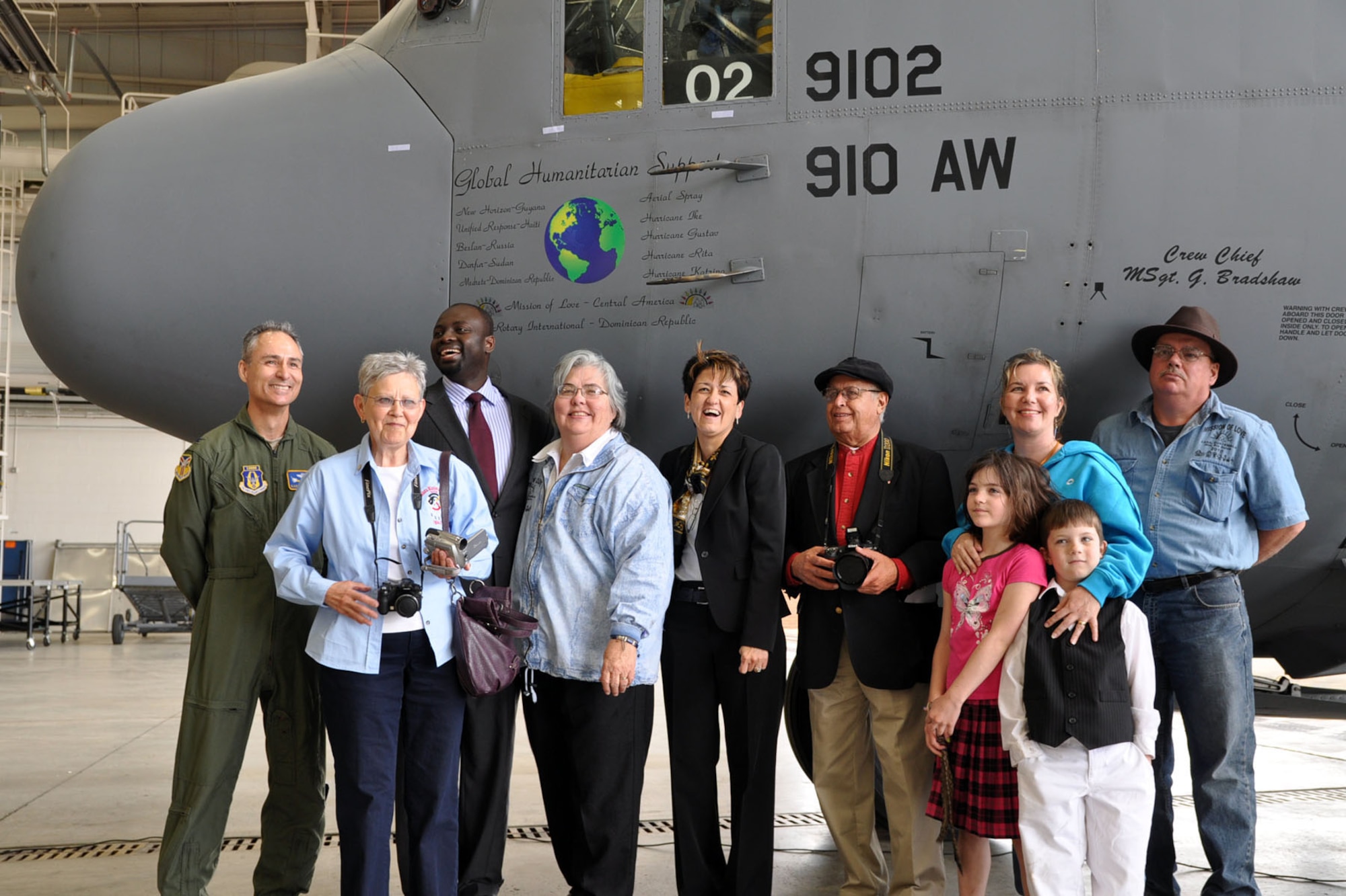 YOUNGSTOWN AIR RESERVE STATION, Ohio -- Air Force Reserve Col. Karl McGregor, commander of the 910th Airlift Wing, poses with a group of volunteers from "Mission of Love" during a nose art unveiling ceremony here, April 7. The nose art titled "Global Humanitarian Support" recognizes the humanitarian missions cariied out by the Citizen Airmen and aircraft of the 910th over the last several years. These missions have included aerial spray relief in the aftermatch of several hurricanes, medical services, civil engineer work and airlift support to numerous location around the world. One of the aspects of the wing's airlift mission is supporting the Denton Program, a government program that enables groups such as "Mission of Love" to utilize military airlift to transport donated goods to those in need at overseas locations. U.S. Air Force photo by Tech. Sgt. Dennis Kilker Jr.