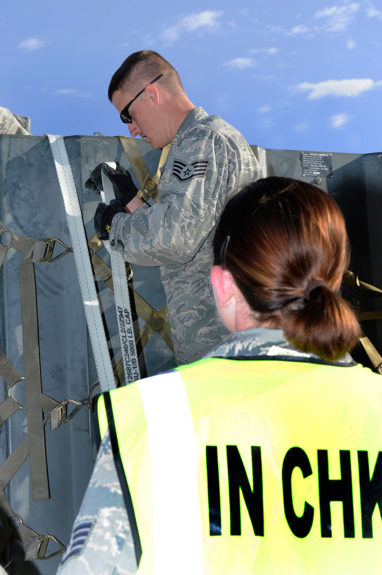 HOLLOMAN AIR FORCE BASE, N.M. -- Staff Sgt. Lara Riley, 49th Logistics Readiness Squadron, inspects property being secured with cargo straps by Staff Sgt. Daryle Braswell, 49th Civil Engineer Squadron, before it is shipped during a Phase I exercise April 14, 2010. Members of Team Holloman routinely participate in exercises such as this one to practice their readiness to deploy at a moment's notice. (U.S. Air Force photo by Airman 1st Class Eileen Payne / Released)