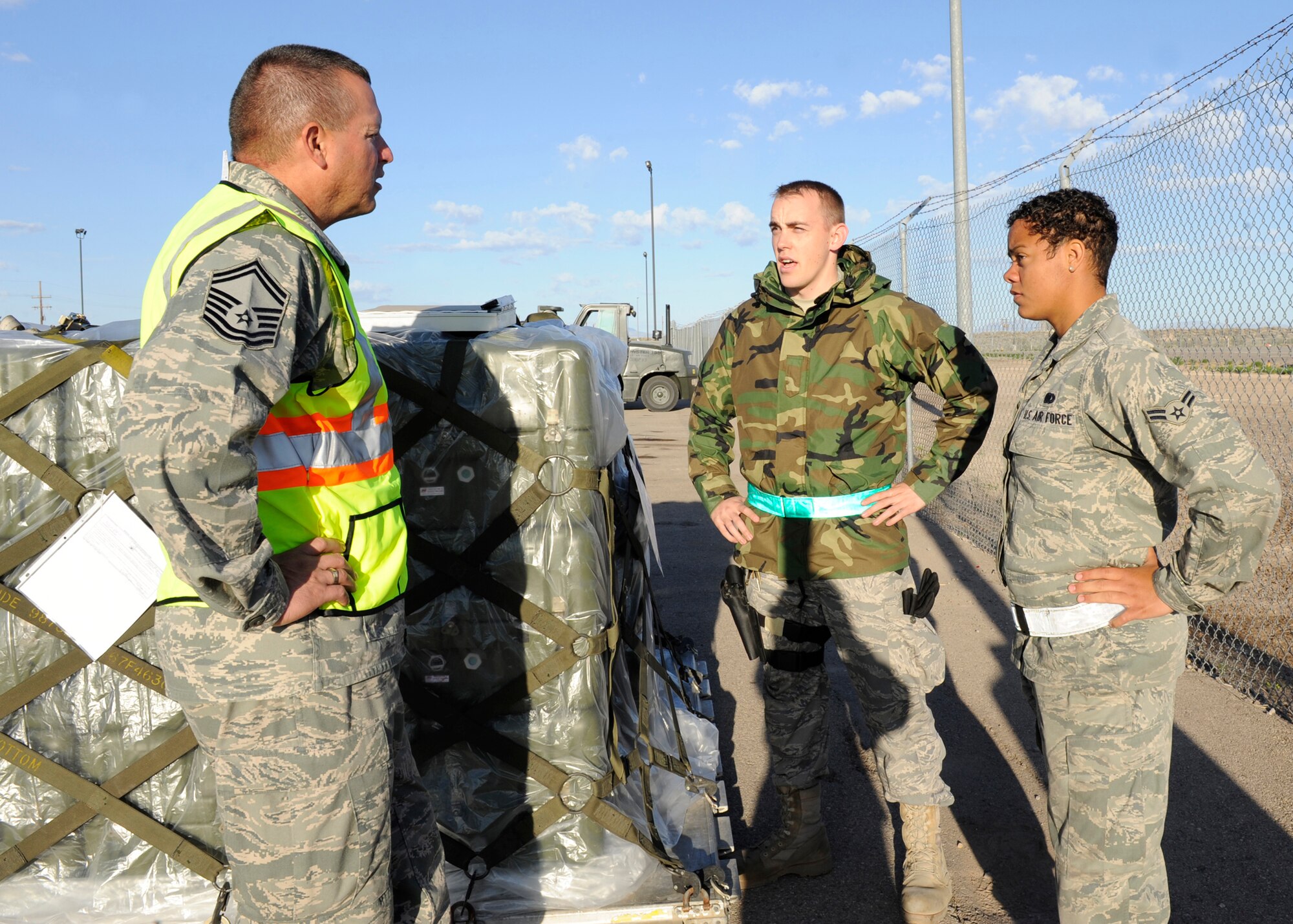 HOLLOMAN AIR FORCE BASE, N.M. -- Senior Master Sgt. Daniel Lucero, 49th Logistics Readiness Squadron, questions Airmen 1st Class Corinna Grimm and Brenton Hodges, 49th LRS, while they guard a pallet of weapons waiting to be loaded onto a C-130 during an exercise April 14, 2010. Airmen Grimm and Hodges had assumed responsibility and armed up to guard the weapons as they waited for 49th Security Forces Squadron members to escort them. Members of Team Holloman participate in exercises such as this one routinely to practice their readiness to deploy at a moment's notice. (U.S. Air Force photo by Airman 1st Class Eileen Payne / Released)
