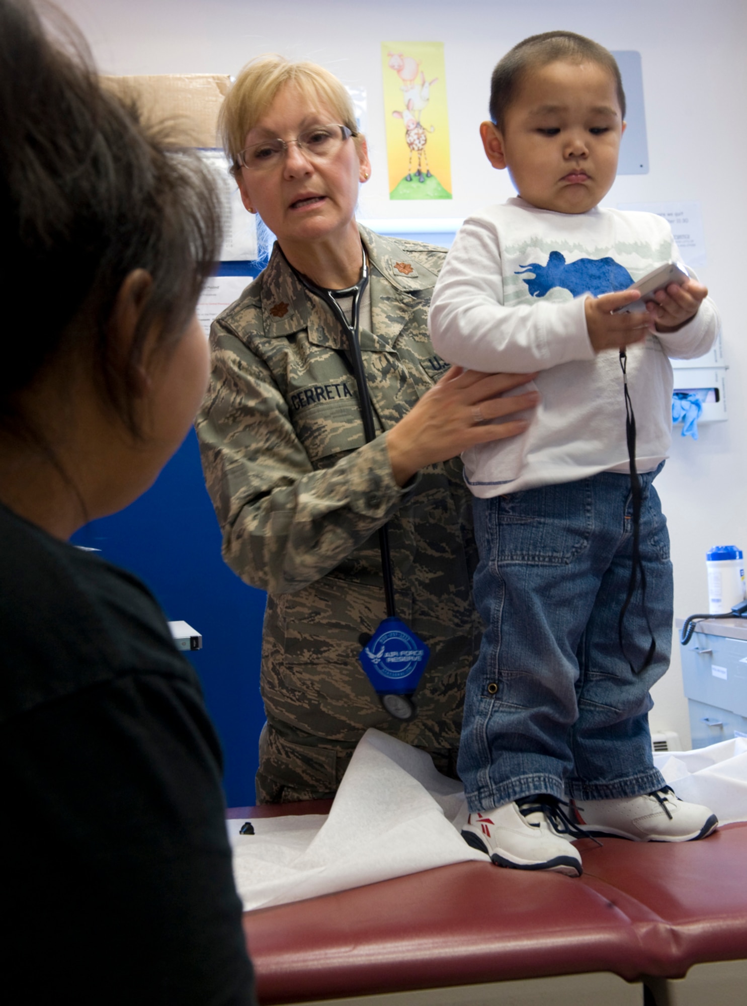 Maj. Emily Cerreta consults Laura Ballot, mother of 23-month-old Hikerr Snyder, during his well-baby checkup April 14, 2010, in Noorvik, Alaska. Major Cerreta is a family nurse practitioner from the 433rd Airlift Wing at Lackland Air Force Base, Texas, and is in Alaska for Operation Arctic Care, a joint medical training exercise.  (U.S. Air Force photo/Master Sgt. Jack Braden)