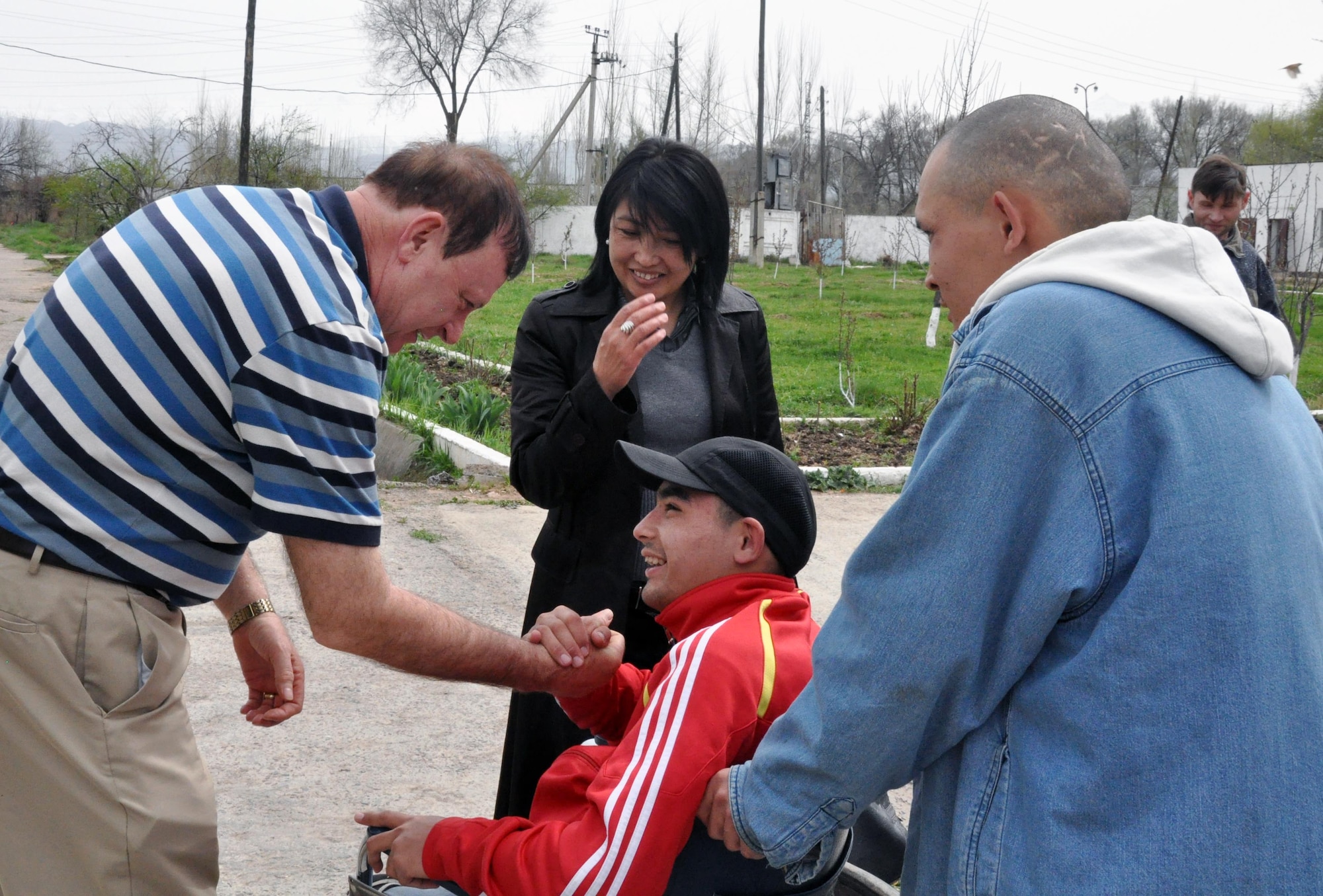 Transit Center at Manas head chaplain Lt. Col. James Kinsey shakes hands with a resident of the Psychoneurologic Boarding House in Iskra Village, Kyrgyzstan, during a humanitarian assistance visit April 14, 2010. Airmen from the Transit Center visited to bring food, clothing, and some entertainment items and to see how they can help the boarding house in the future. (U.S. Air Force photo/Staff Sgt. Carolyn Viss)