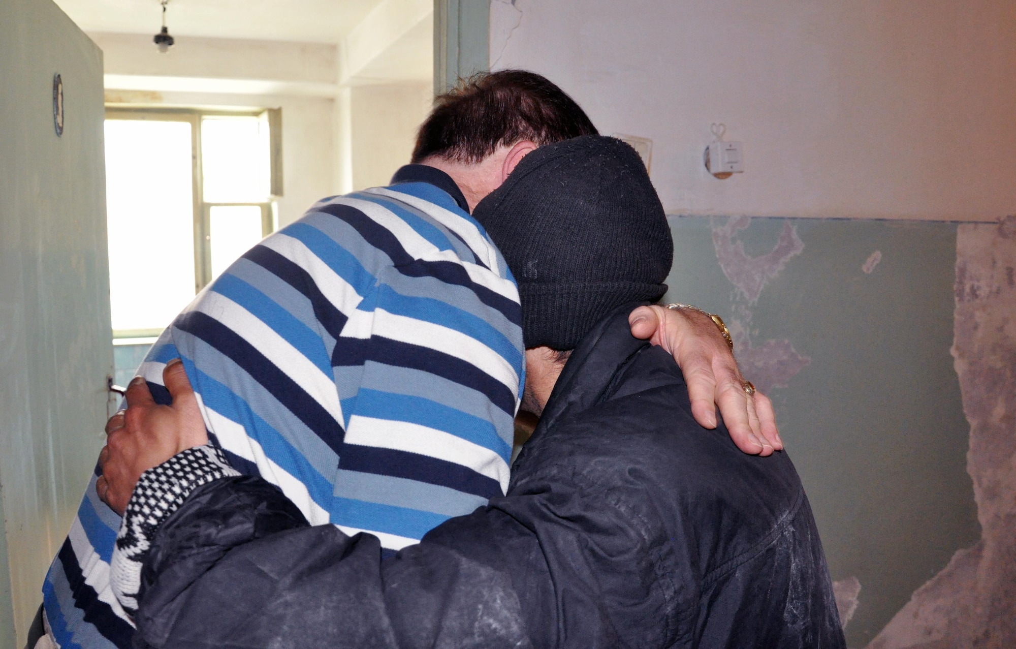 Transit Center at Manas head chaplain Lt. Col. James Kinsey hugs a resident of the Psychoneurologic Boarding House in Iskra Village, Kyrgyzstan, during a humanitarian assistance visit April 14, 2010. Airmen from the Transit Center visited to bring food, clothing, and some entertainment items and to see how they can help the boarding house in the future. (U.S. Air Force photo/Staff Sgt. Carolyn Viss)