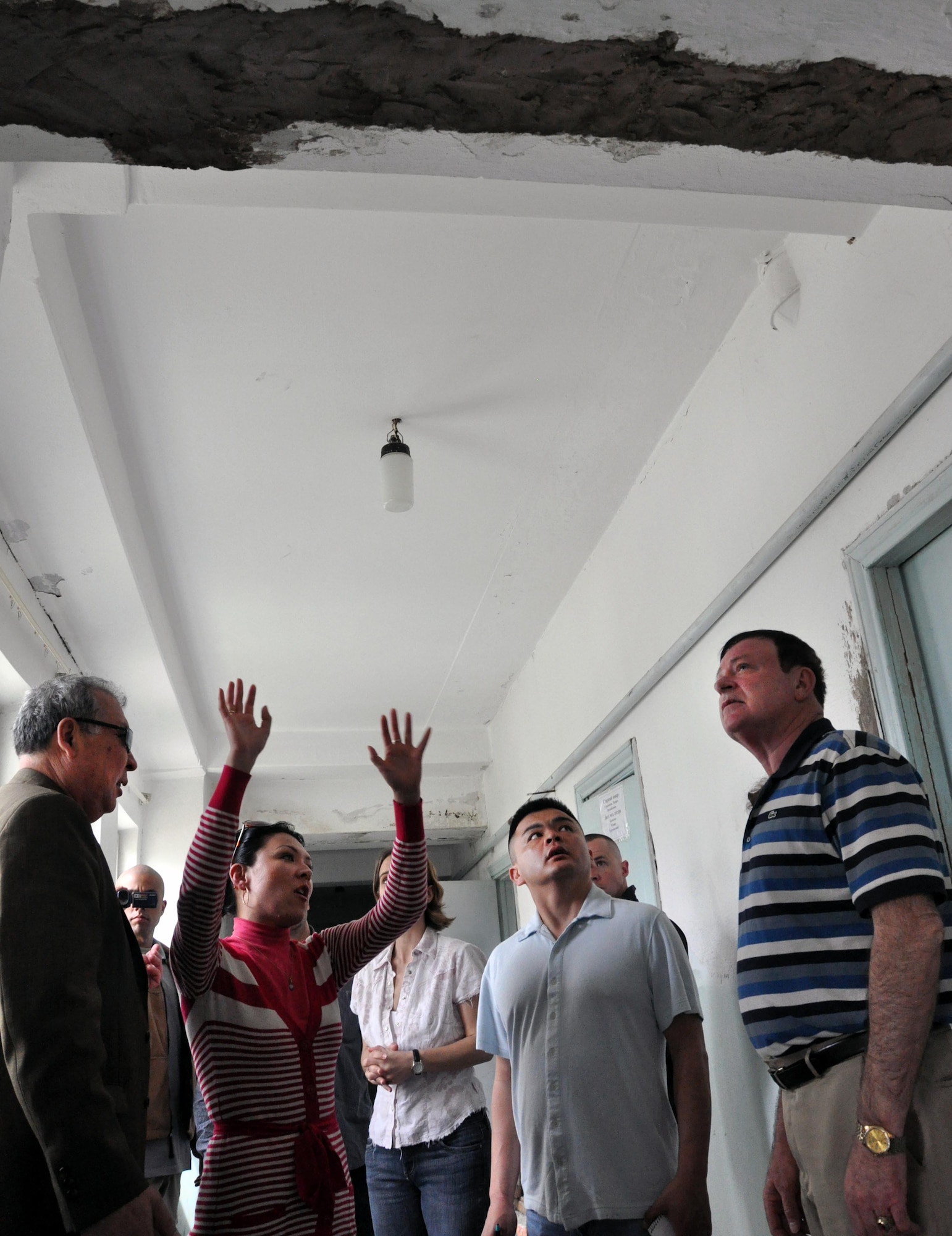 A Kyrgyz translator explains what structural repairs need to be made at the TokMok Psychoneurologic Boarding House April 14, 2010, in Iskra Village, Kyrgyzstan. Transit Center at Manas Airmen visited to bring food, clothing, and some entertainment items and to see how they can help the boarding house in the future. (U.S. Air Force photo/Staff Sgt. Carolyn Viss)