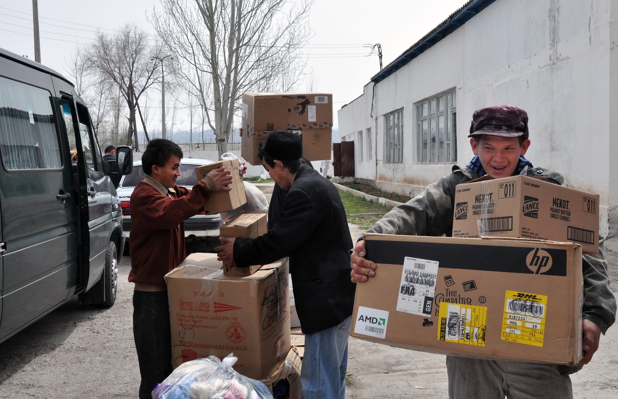 Residents of the TokMok Psychoneurologic Boarding House in Iskra Village, Kyrgyzstan, help carry items the Airmen from the Transit Center at Manas brought during a humanitarian assistance visit April 14, 2010. This boarding house hosts 255 male patients and is badly in need of repair and basic amenities. Airmen from the Transit Center at Manas visited to bring food, clothing, and some entertainment items and to see how they can help the boarding house in the future. (U.S. Air Force photo/Staff Sgt. Carolyn Viss)