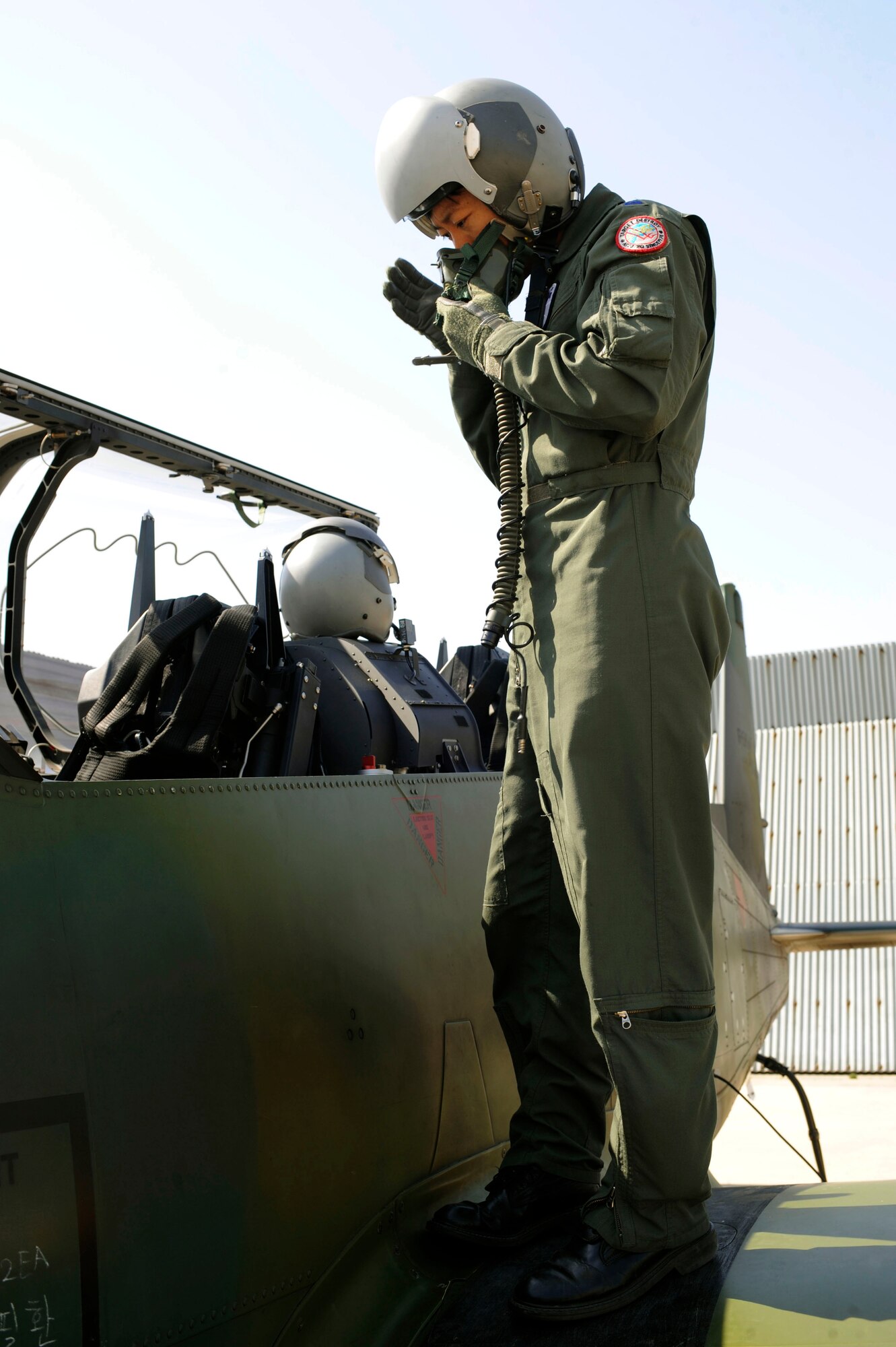Maj. Jwa-Ryong Park puts his helmet on, part of his preparations before taking off in his KA-1 aircraft April 15 at Osan Air Base, Republic of Korea. Major Park is the 237th Tactical Fighter Squadron intelligence commander from Seoul, ROK. Major Park and 237th TFS members are here participating in Buddy Wing, a joint, bi-yearly training exercise involving the ROK Air Force and the U.S. Air Force. (U.S. Air Force photo/Staff Sgt. Stephenie Wade)