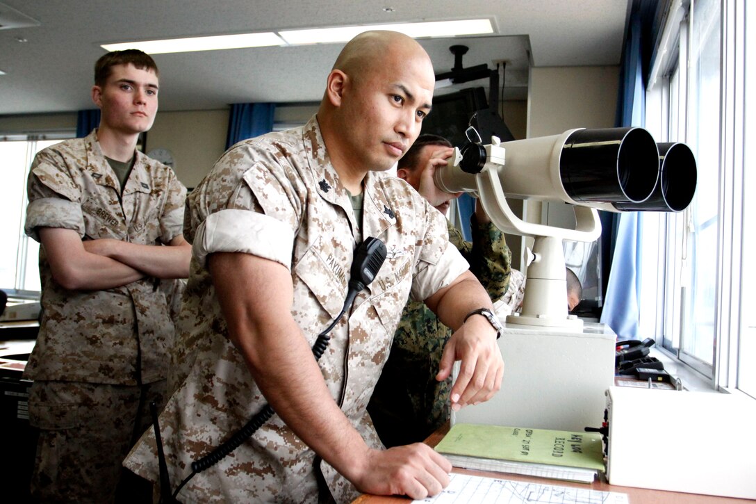 Seaman Apprentice Ronald Brewer (left) and Petty Officer 1st Class George Payumo (center) observe harbor operations in order to keep the station safe and ready for any situation. The Harbor Operations Division aboard the air station is a small team made up of Navy personnel who are experts in communication, safety and operational risk management.