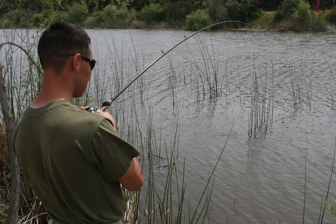 Sgt. Jacob D. Melrose, an armorer with Headquarters and Headquarters Squadron, Marine Corps Air Station Miramar, 3rd Marine Aircraft Wing, I Marine Expeditionary Force, reels in a fish at the fish pond here April 16. Melrose fishes in tournaments during his spare time.