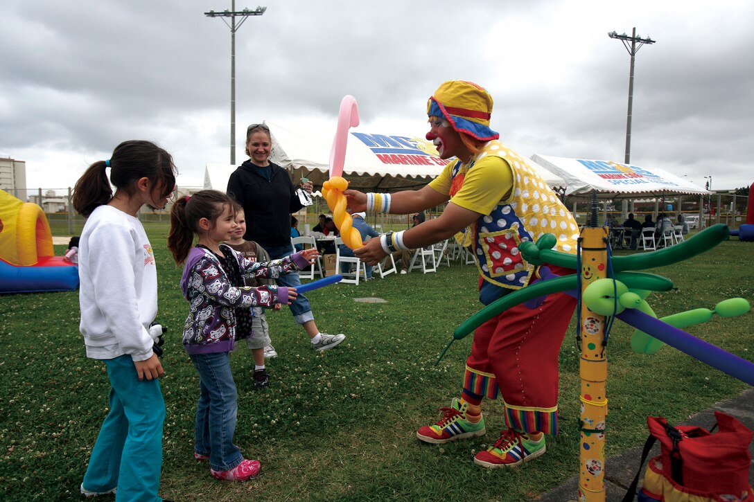 Kotora the Clown hands Misty Patterson, 7, a balloon heart during the Month of the Military Child Awareness fair on Camp Kinser April 16.