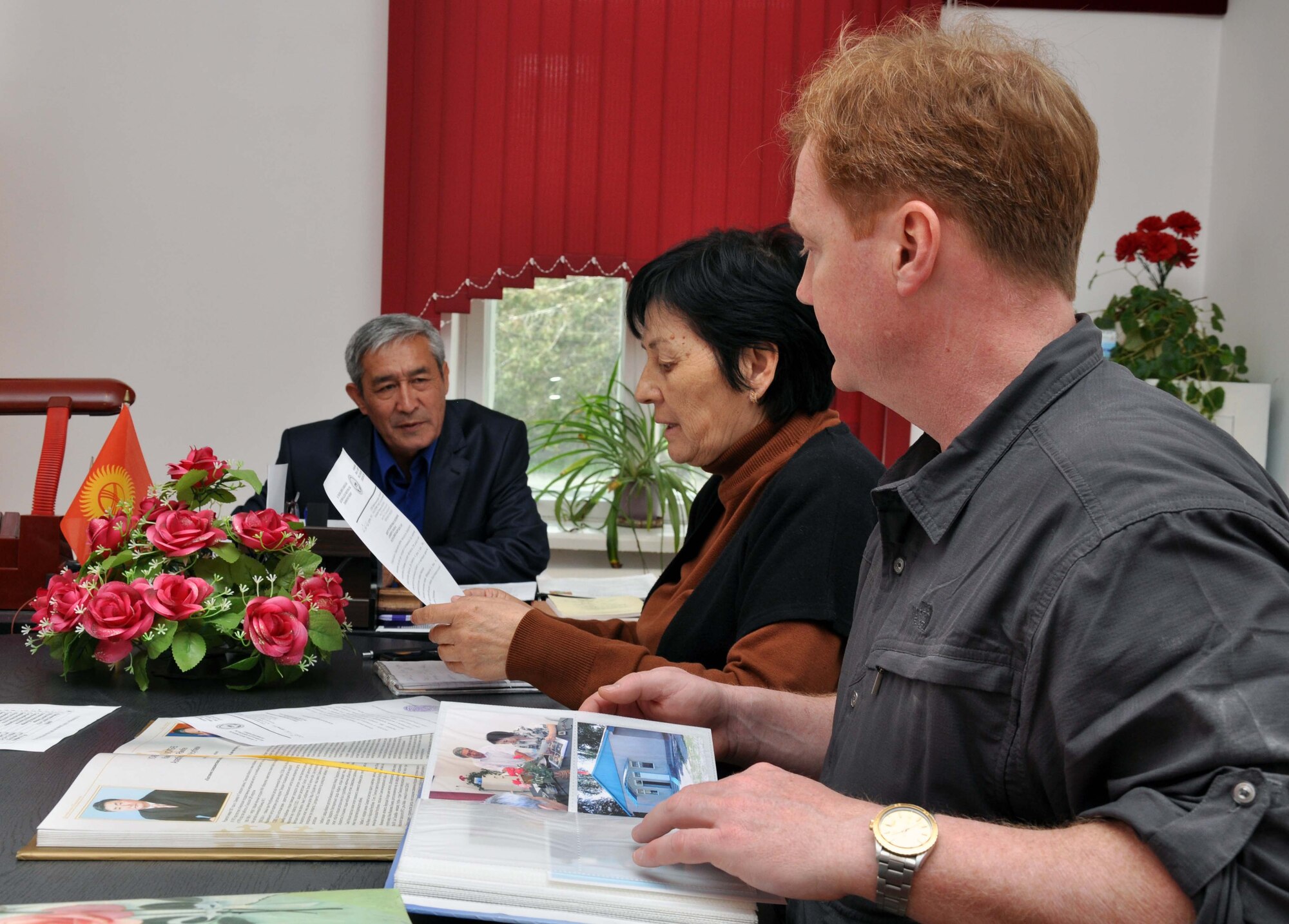 Valentina Turabekova translates a thank you letter from Usubbaev Raimbek, director of the Panfilovskaya Boarding School/Orphanage, to U.S. Air Force Lt. Col. Neal Linch, the Transit Center at Manas humanitarian assistance director, and all the Airmen who delivered food and visited the school April 16, 2010. (U.S. Air Force photo/Staff Sgt. Carolyn Viss)