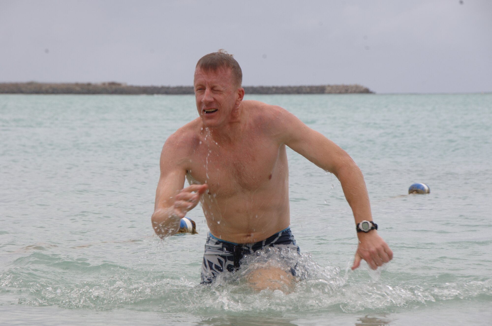 Lt. Col. Rodger Phillips, 15th Contracting Squadron, emerges from the ocean as he heads toward the shore to finish his leg of the fitness challenge at Hickam Harbor Apr. 16. Team Hickam Sports Day is an annual event designed to celebrate fitness and increase the morale of personnel stationed here. (U.S. Air Force photo by Senior Airman Nathan Allen)