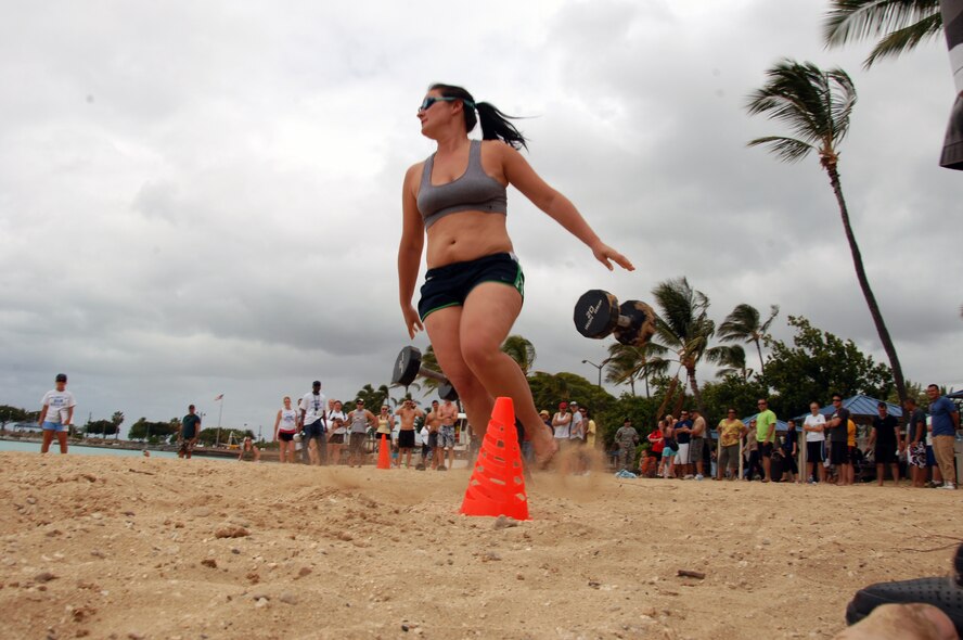 Staff Sgt. Casey Shaner, 15th Contracting Squadron, drops twenty pound weights as she heads toward the ocean for the swimming portion of the fitness challenge at Hickam Harbor Apr. 16. Team Hickam Sports Day is an annual event designed to celebrate fitness and increase the morale of personnel stationed here. (U.S. Air Force photo by Senior Airman Nathan Allen)