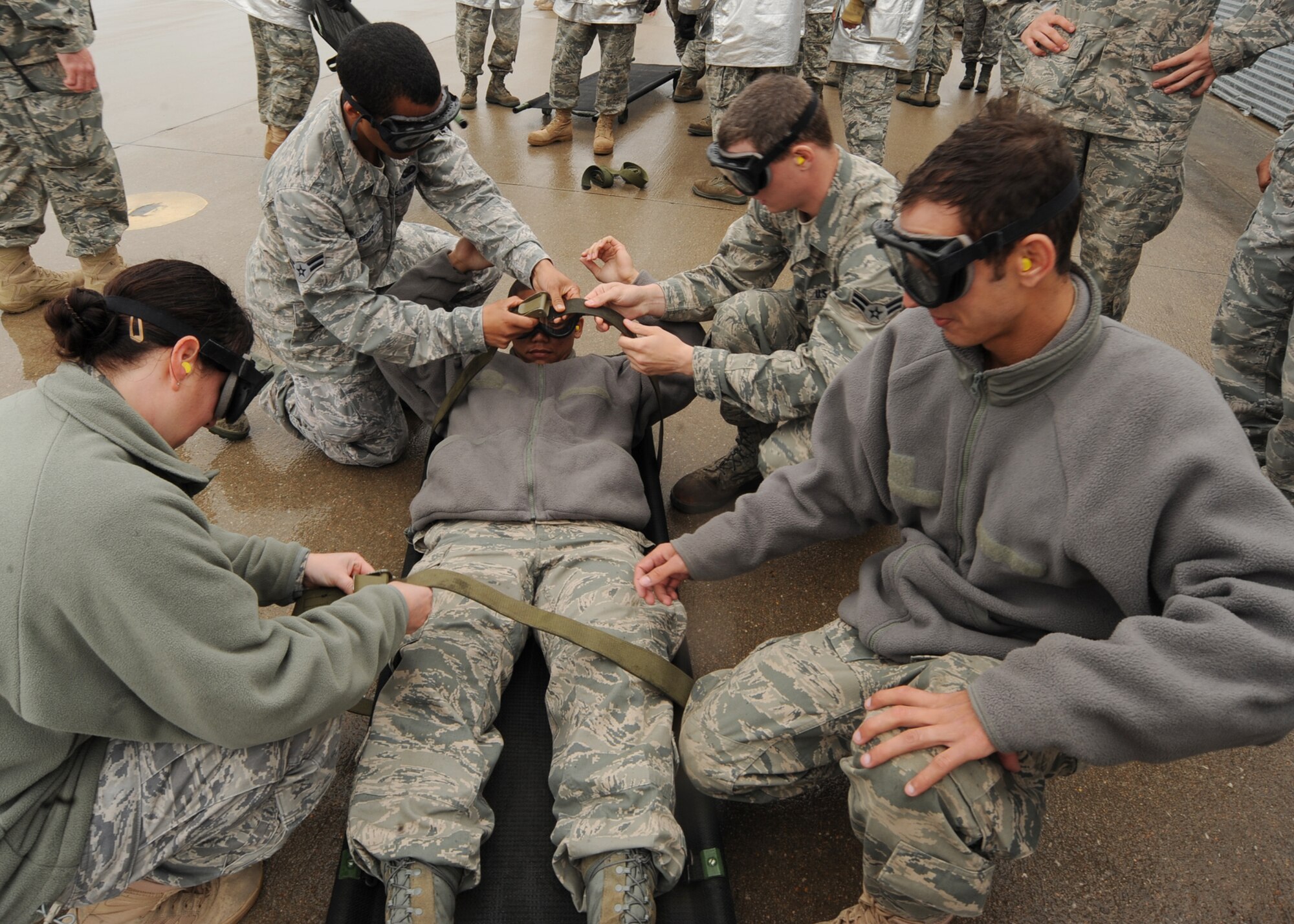 Team McConnell Airmen secure a "patient" in a North Atlantic Treaty Organization gurney during an expeditionary medical readiness training exercise on the flightline, April 16, 2010, McConnell Air Force Base, Kan. The training provided Airmen familiarity with the aircraft and aids in the success of working in and around Black Hawks in combat environments. (U.S. Air Force photo/Senior Airman Maria Ruiz)