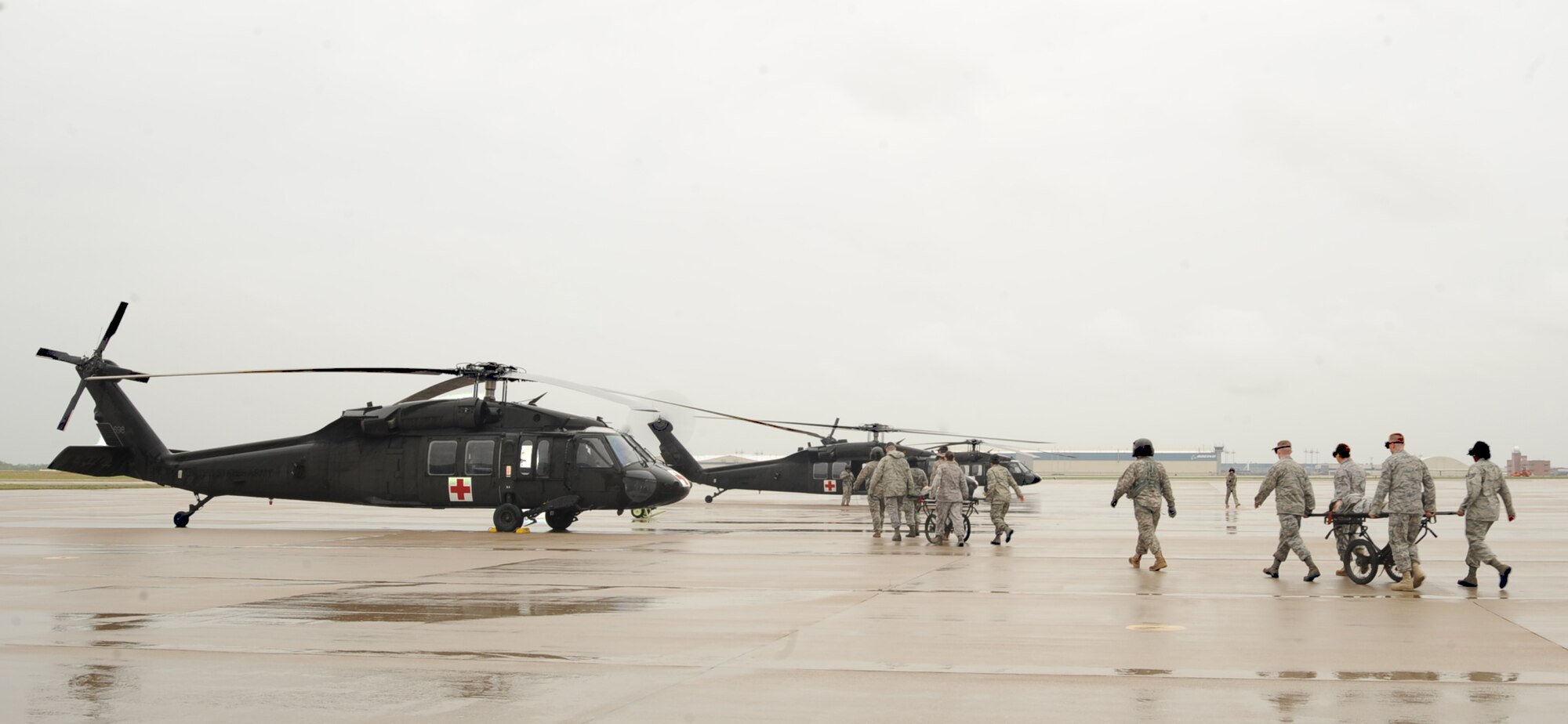Team McConnell Airmen use North Atlantic Treaty Organization gurneys to carry “patients” to UH-60Q Black Hawk helicopters during an expeditionary medical readiness training exercise on the flightline, April 16, 2010, McConnell Air Force Base, Kan. The training provided the Airmen familiarity with the aircraft and aids in the success of working in and around Black Hawks in combat environments. (U.S. Air Force photo/Senior Airman Maria Ruiz)