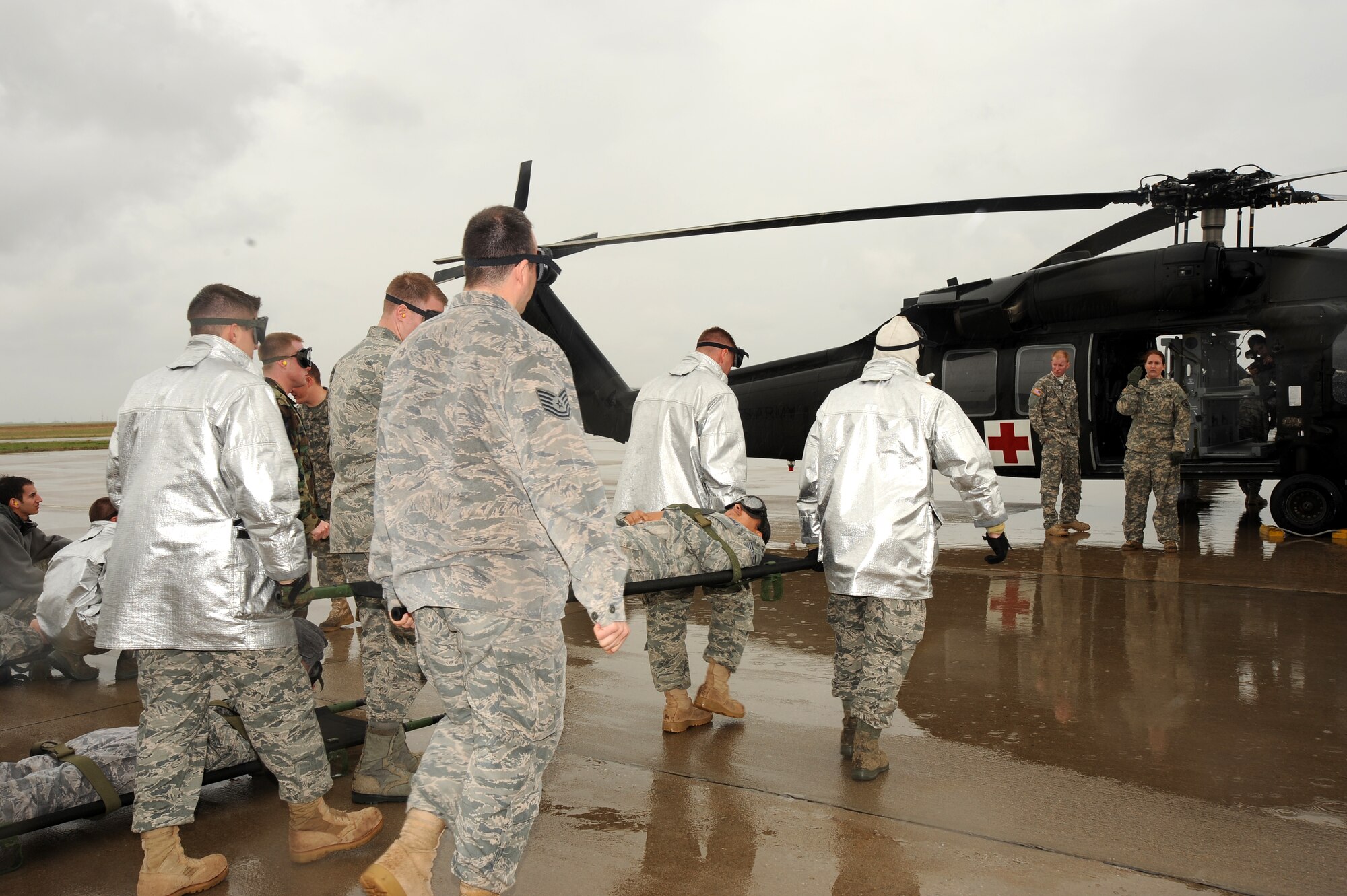Team McConnell members load a “patient” on to a UH-60Q Black Hawk helicopter during a joint medical evacuation exercise which included loading and unloading "patients" on a helicopter on April 16, 2010, McConnell Air Force Base, Kan. Team McConnell Airmen performed in a medical evacuation exercise with three UH-60Q Blackhawk Medevac Helos from the Nebraska Army National Guard. In wartime areas of responsibility, helicopters are the primary vehicle for patient transport due to their ability to rapidly transfer patients and reach remote or austere terrain. This exercise was conducted to train Air Force and Army personnel in a simulated scenario prior to conducting operations in a deployed, hostile environment. (U.S. Air Force photo/Tech. Sgt. Chyrece Campbell)