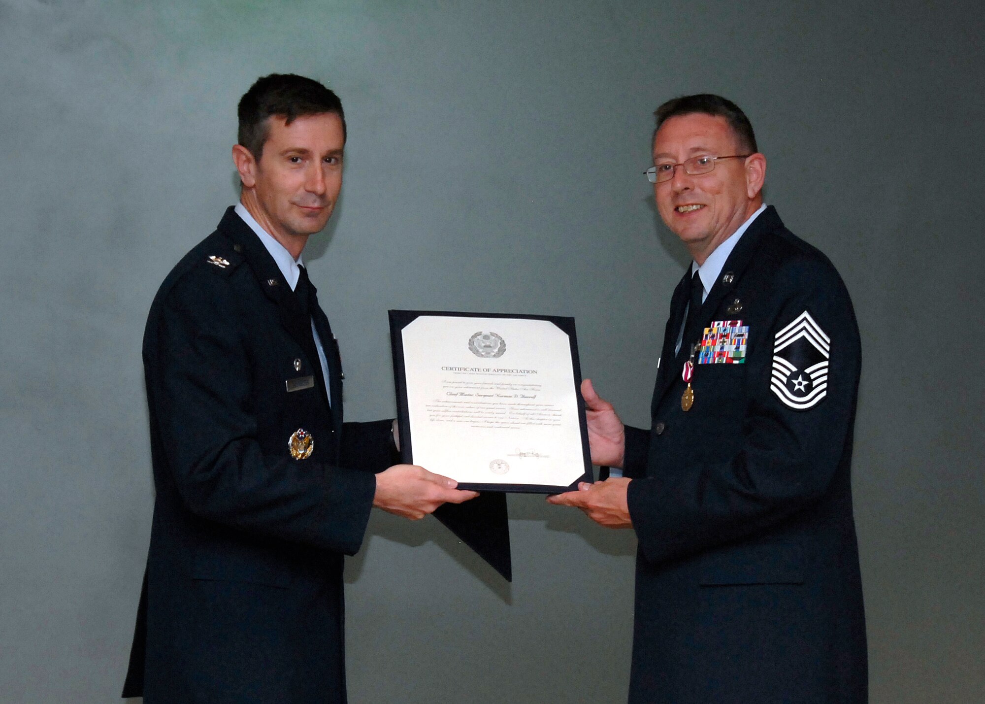 Col. Kevin Schneider, 80th Flying Training Wing commander, presents Chief Master Sgt. Norman Thierolf with his a certificate of appreciation during the chief’s retirement ceremony, April 16, 2010. Chief Thierolf retired after serving 30 years in the Air Force. (U.S. Air Force Photo/Michael Litteken)