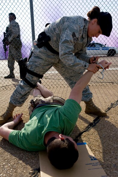 BARKSDALE AIR FORCE BASE, La. – Senior Airman Shana Simmons, 2d Security Forces Squadron, simulates apprehending a protester for trying to gain entry to the flight line during a Major Accident Response Exercise here April 16. The MARE was conducted to test the readiness of emergency response personnel in the event of an accident during the upcoming air show. (U.S. Air Force photo by Airman 1st Class Chad Warren) (RELEASED)