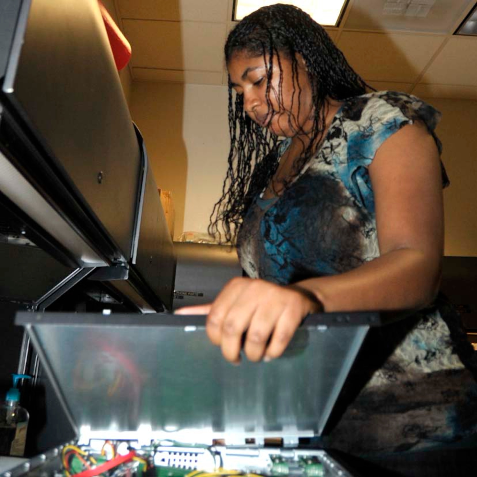 Staff Sgt. Munirih "Moni" Gravelly, who also works full time as a 931st Mission Support Flight client support technician, performs maintenance on a computer. (U.S. Air Force photo/Capt. Tim Wade)