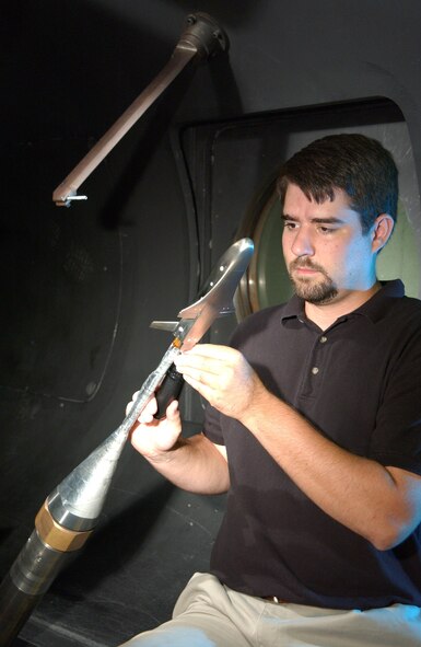 Joe Norris, AEDC White Oak project engineer, puts the finishing touches on the X-37 model prior to testing at Mach 14 in Hypervelocity Wind Tunnel 9.