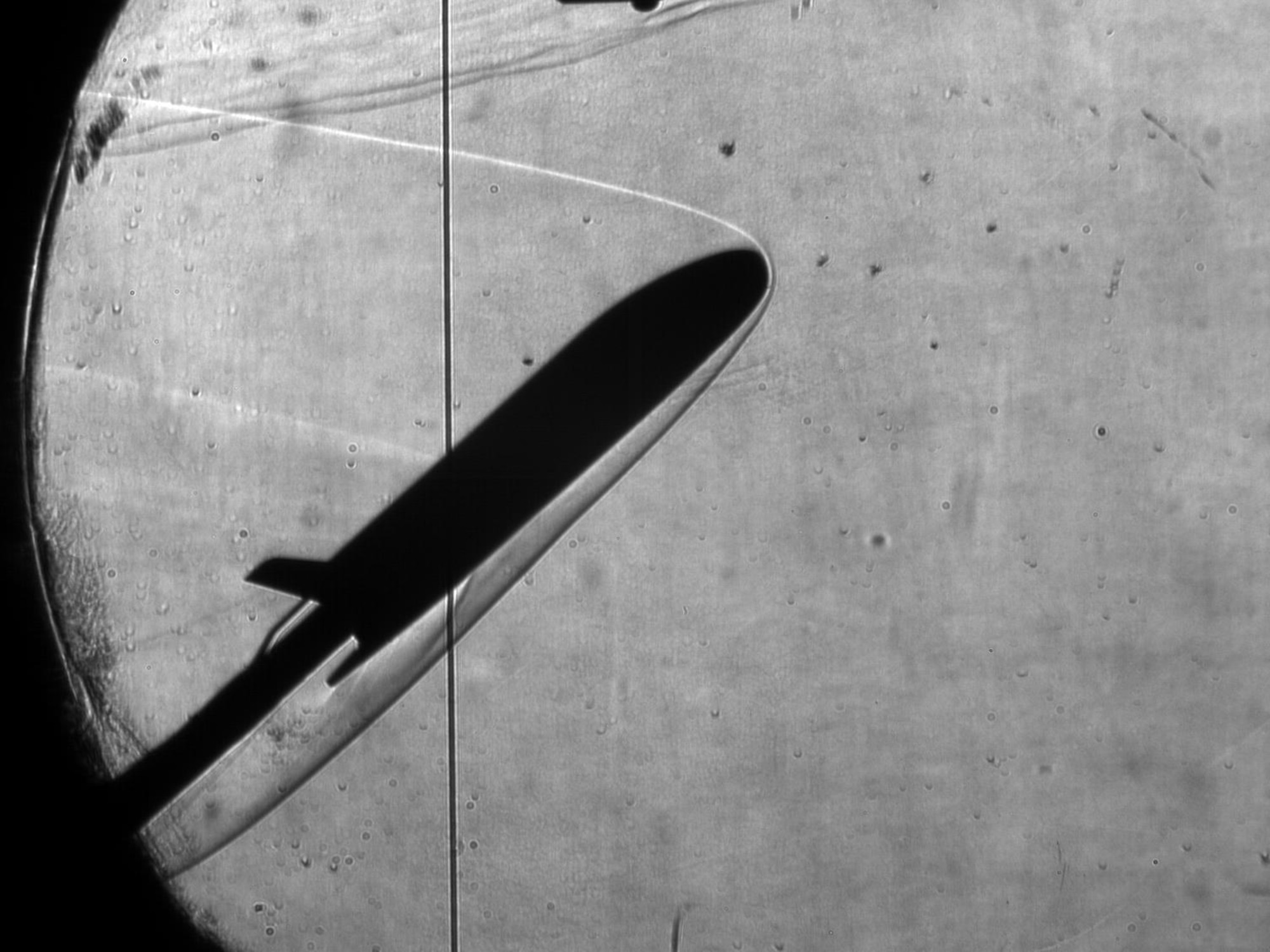 This is one of the Schlieren images of the X-37’s plume interacting with the flow along the model’s surface during testing in AEDC’s von Kàrmàn Gas Dynamics Facility wind tunnels.