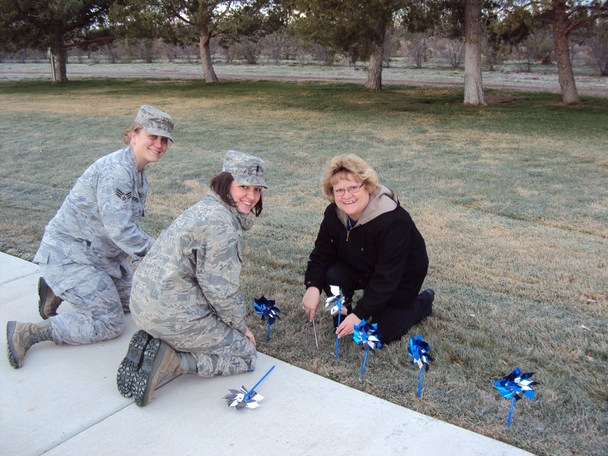 MOUNTAIN HOME AIR FORCE BASE, Idaho - Senior Airman Amanda Froman, 366th
Medical Operations Squadron Mental Health technician, 1st Lt. Kristene
Harris, Family Advocacy Officer and Connie Powers, Family Advocacy Outreach
Manager, help "plant" some of the 60 blue and silver pinwheels along
Gunfighter Avenue near the main gate. The pinwheels are used to raise
awareness and educate families about Child Abuse Prevention Awareness Month.
Organizations throughout the state are raising awareness through a variety
of activities from training sessions and presentations to exhibitions and
community events. (Courtesy photo)