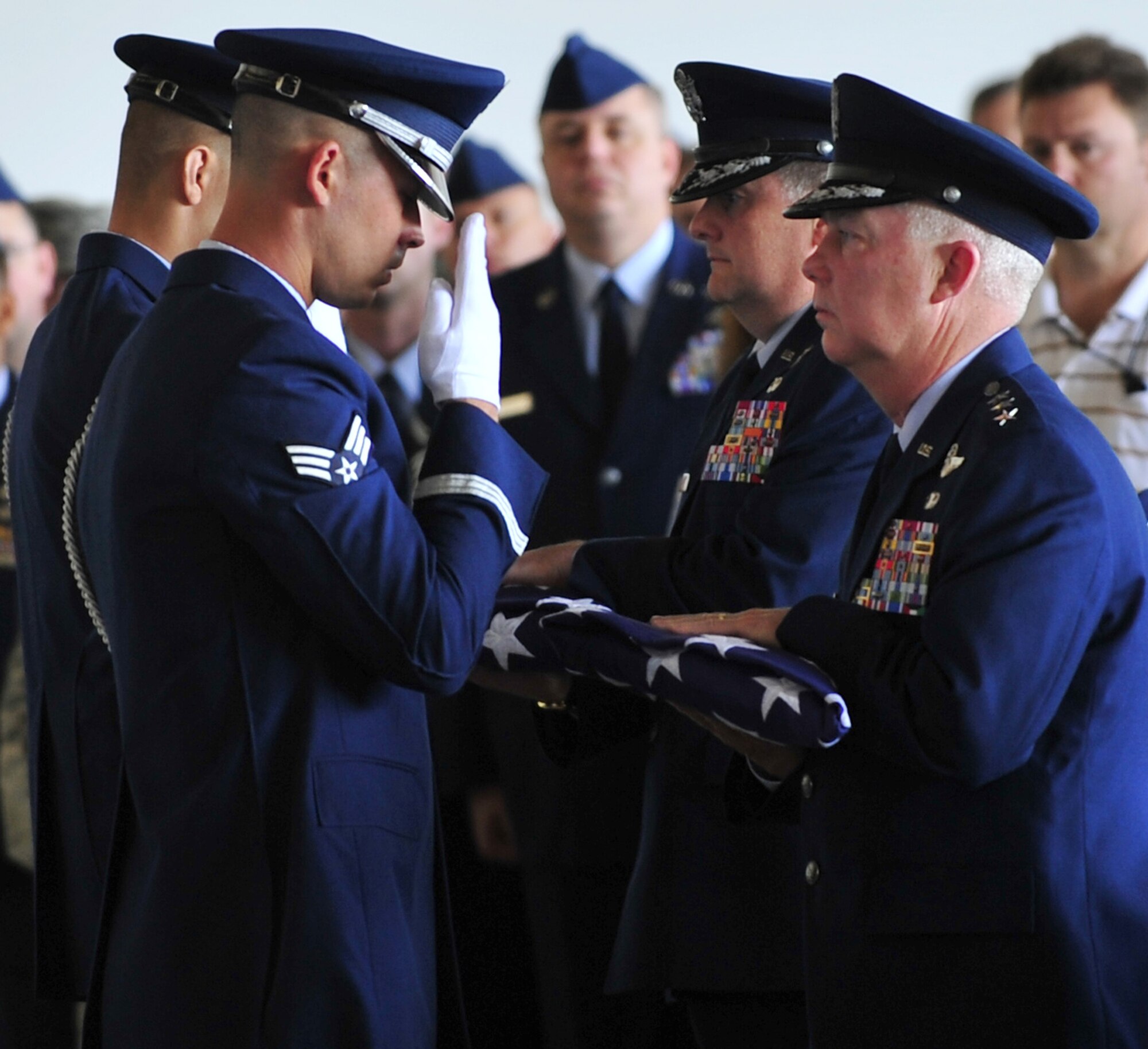 During a memorial service honoring Maj. Randell Voas and Senior Master Sgt. James Lackey April 15 at the Freedom Hangar here, Lt. Gen. Donald Wurster, Air Force Special Operations Command commander (right foreground), and Brig. Gen. Marshall Webb, 23rd Numbered Air Force commander (right background), receive folded American flags from Hurlburt Field Honor Guard members for presentation to the families of the fallen Airmen.  Major Voas and Sergeant Lackey, assigned to the 8th Special Operations Squadron as an evaluator pilot and evaluator flight engineer, respectively,  died inthe line of duty when their CV-22 crashed in Afghanistan April 9. (DoD photo by Senior Airman Sheila deVera)