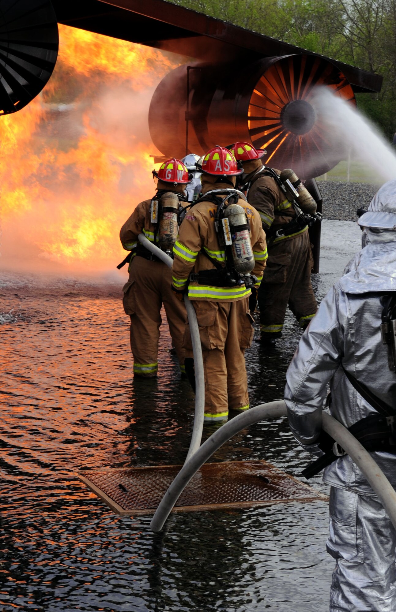 BARKSDALE AIR FORCE BASE, La. – Barksdale and Shreveport firefighters work together to extinguish a fire during their annual joint live fire training here April 7. This training allows firefighters the opportunity to train together, learn tactics and strategies employed by each agency and to build trust in the ability to interoperate at the scene of an emergency. It also allows the incident commanders the ability to setup and utilize a unified command structure as required by the National Incident Management System. (U.S. Air Force photo by Senior Airman La’Shanette V. Garrett)(RELEASED)