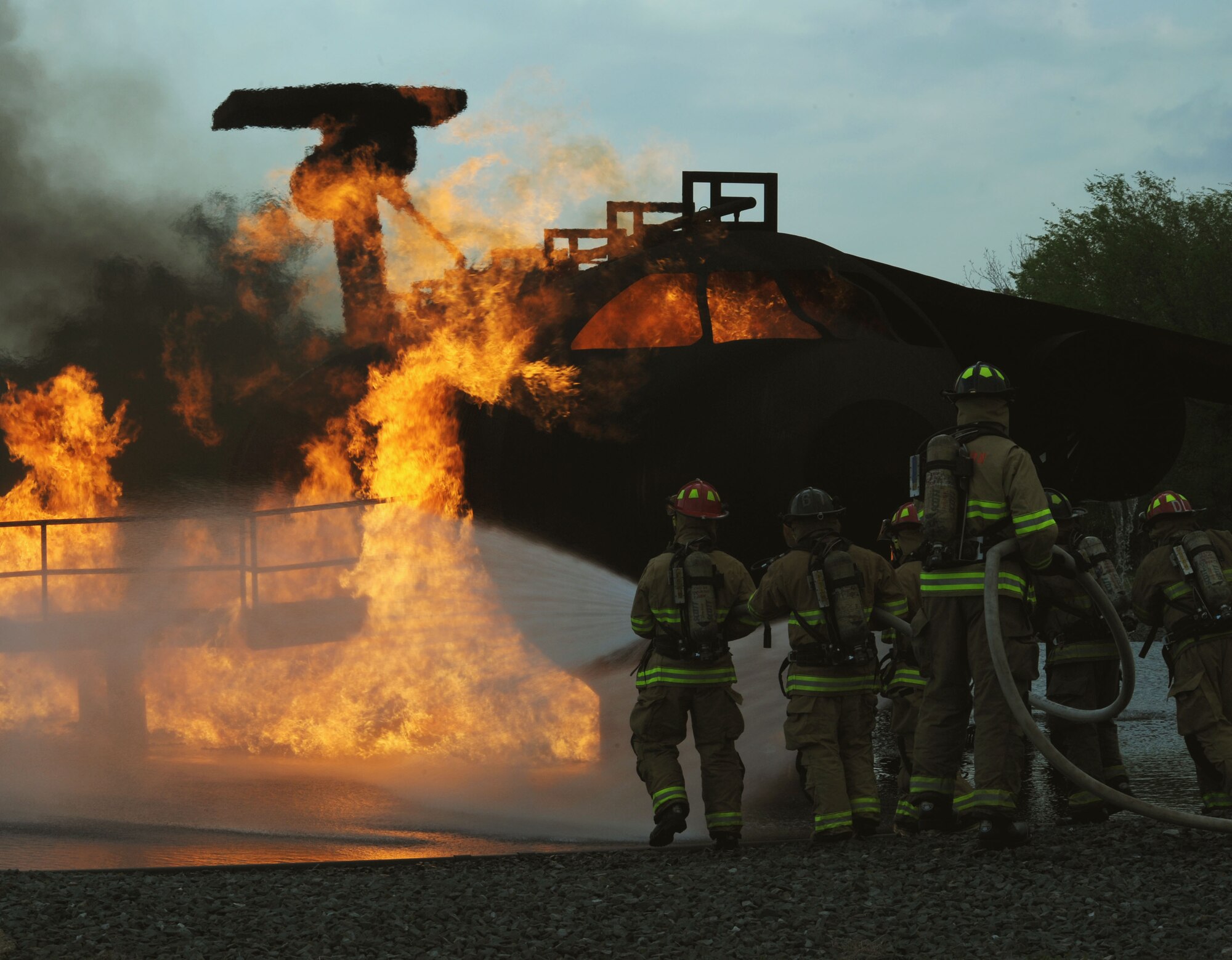 BARKSDALE AIR FORCE BASE, La. – Shreveport firefighters move in to extinguish a fire during their annual joint - live fire training here April 7. Firefighters wear proximity firefighting gear since there is no training gear for this purpose. The special aluminized cover and barrier help reflect some heat away from the firefighters while the self – contained breathing apparatus allows them to breathe clean air for approximately 40 minutes in working conditions. The proper wear is imperative to their safety and survival, since the entry into the training aircraft exposes them to temperatures reaching 2,000 degrees Fahrenheit. (U.S. Air Force photo by Senior Airman La’Shanette V. Garrett)(RELEASED)