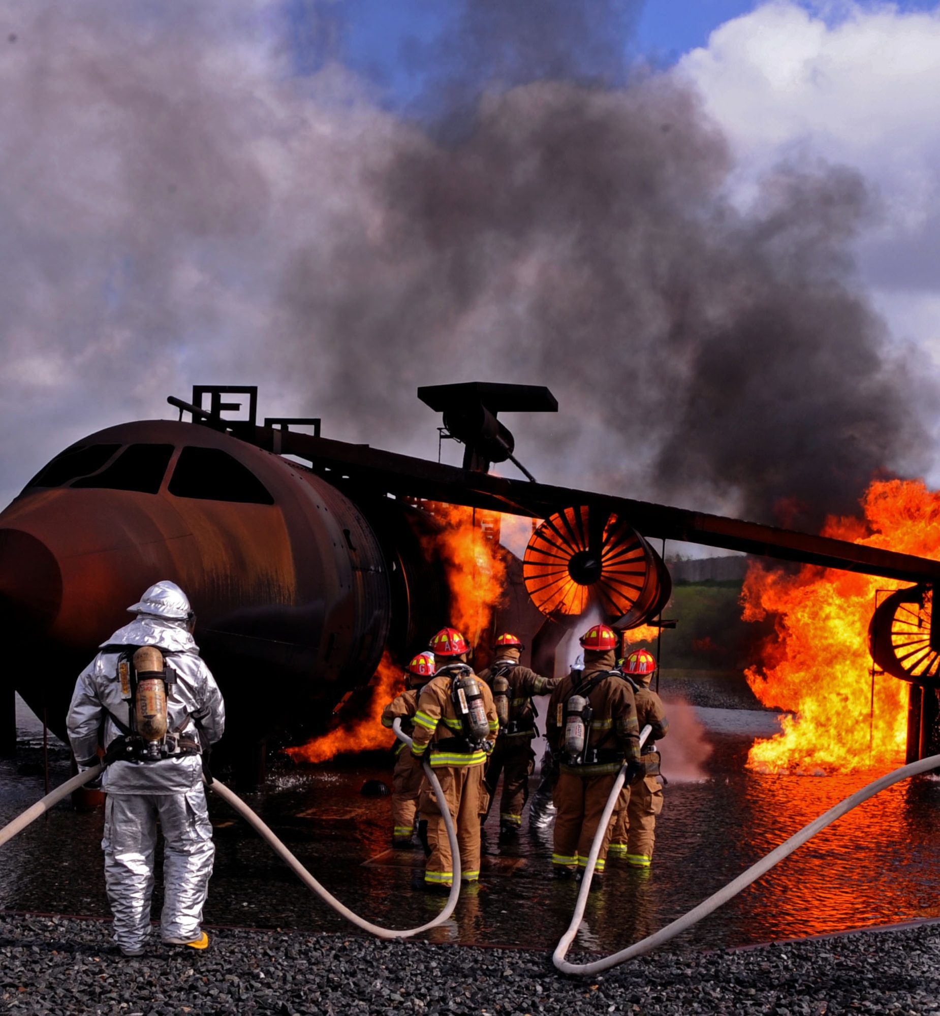 BARKSDALE AIR FORCE BASE, La. – Barksdale and Shreveport firefighters work together to put out a fire in the live fire trainer here April 7. This training aircraft exposes the firefighters to temperatures reaching 2,000 degrees Fahrenheit. (U.S. Air Force photo by Senior Airman La’Shanette V. Garrett)(RELEASED)