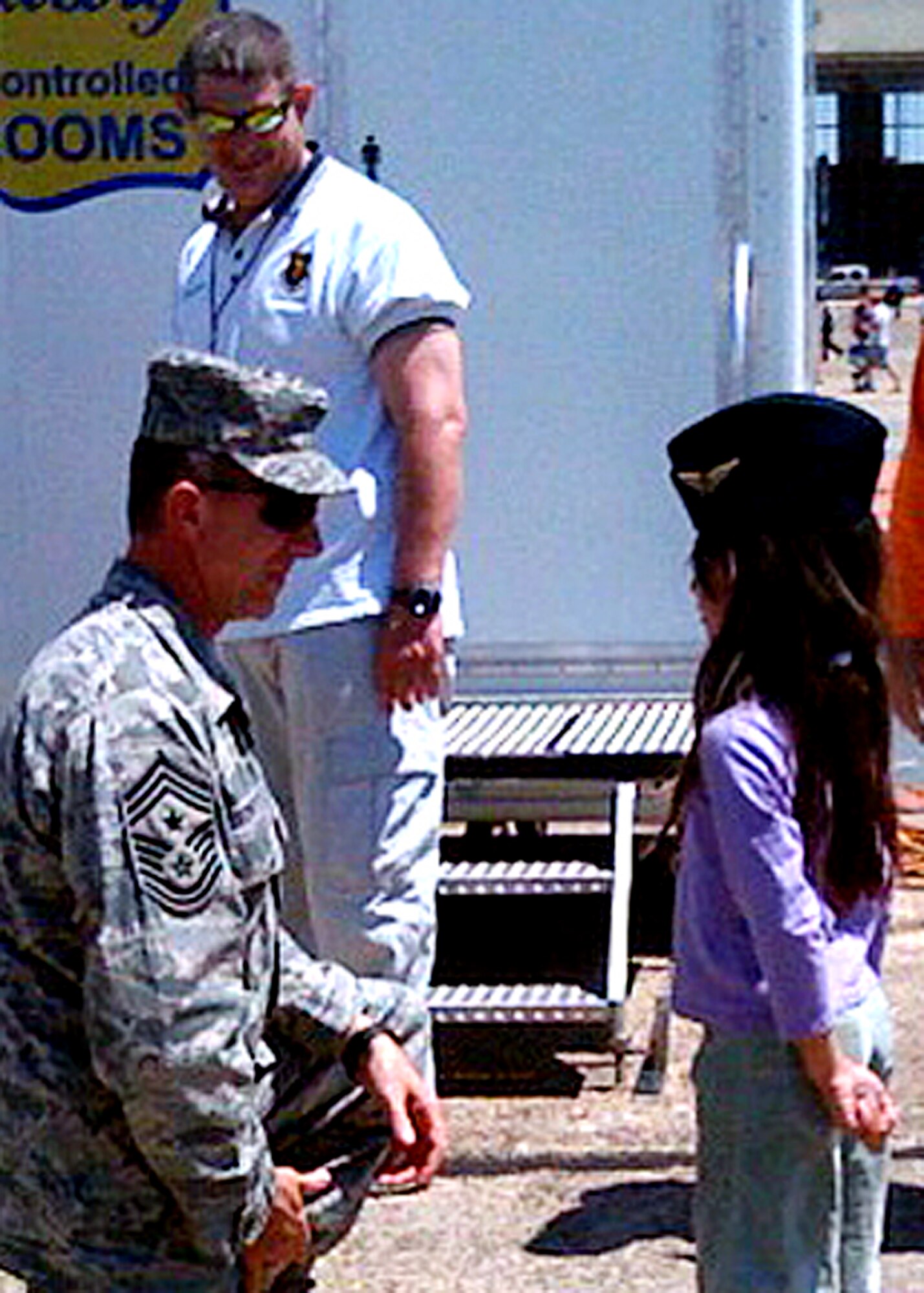 Chief Master Sgt. Thomas Westermeyer, 96th Air Base Wing command chief, receives a coin from 9-year-old "Rizzy" Wieser, (right) during the Eglin airshow April 10.  (Courtesy photo.)