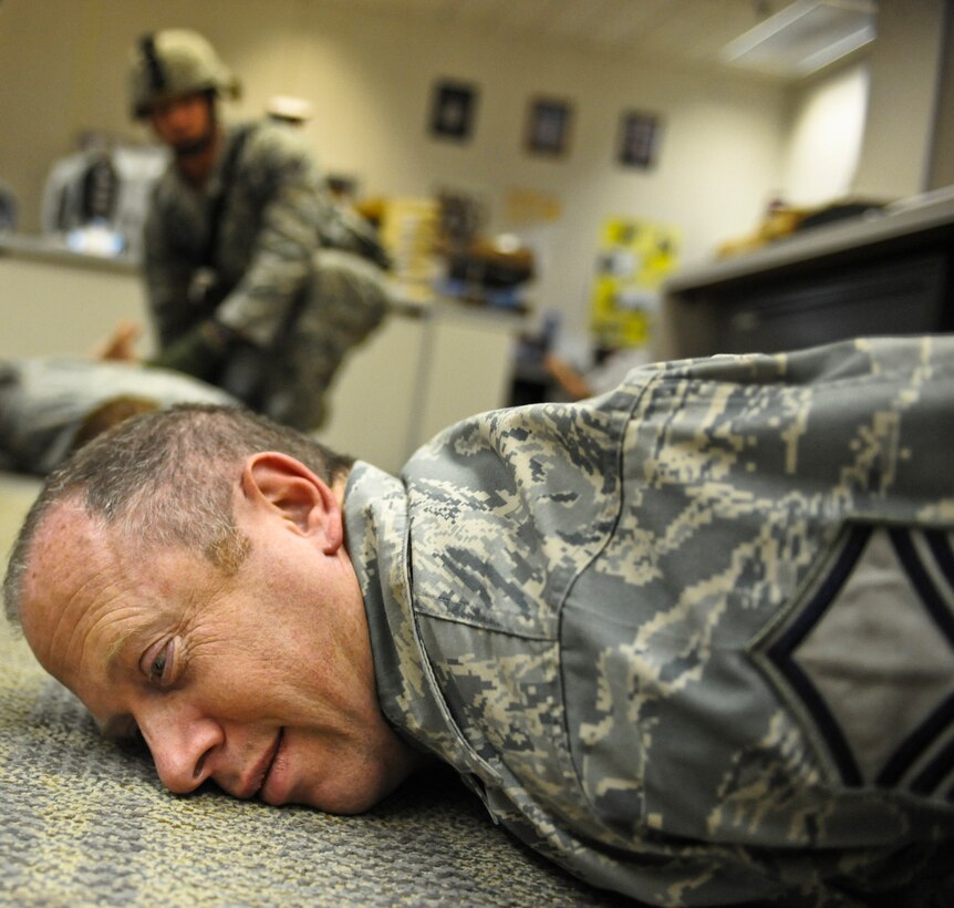 Master Sgt. Loren Bonser, 28th Bomb Wing superintendent of public affairs, is detained during an “active shooter” exercise, April 15. During a room sweep everyone in the room is detained until identified and ruled out as a suspect. (U.S. Air Force photo/Senior Airman Adam Grant)            