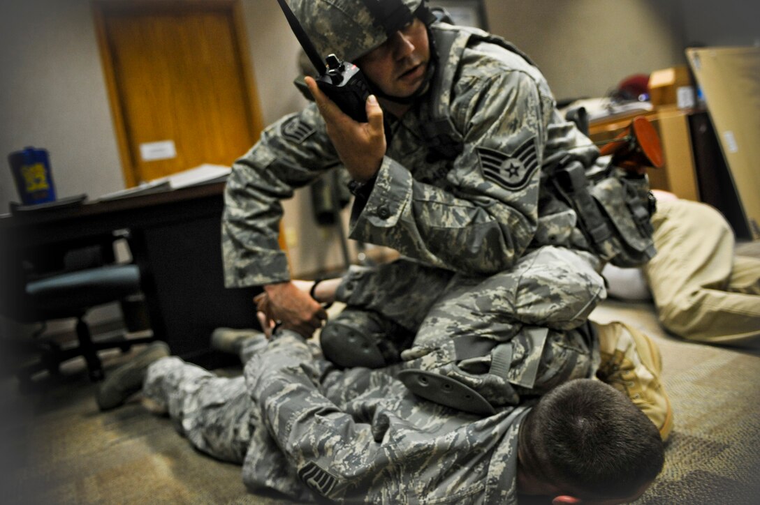 Staff Sgt. Mark Sidle, 28th Security Forces Squadron dog handler, apprehends Tech. Sgt. Aaron Hazen, 28th Bomb Wing NCO in-charge of the executive client support team, during an “active shooter” exercise, April 15. The purpose of the exercise was to test the total reaction and response time of the 28 BW. (U.S. Air Force photo/Senior Airman Adam Grant)            