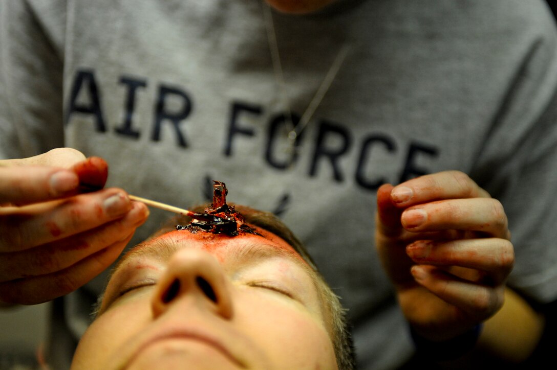 Lt. Col Jason Combs, 28th Bomb Wing director of staff, sits as moulage is placed on him before the beginning of an “active shooter” exercise, April 15. The purpose of the moulage is to give a real-world look to a simulated injury. (U.S. Air Force photo/Senior Airman Adam Grant)  