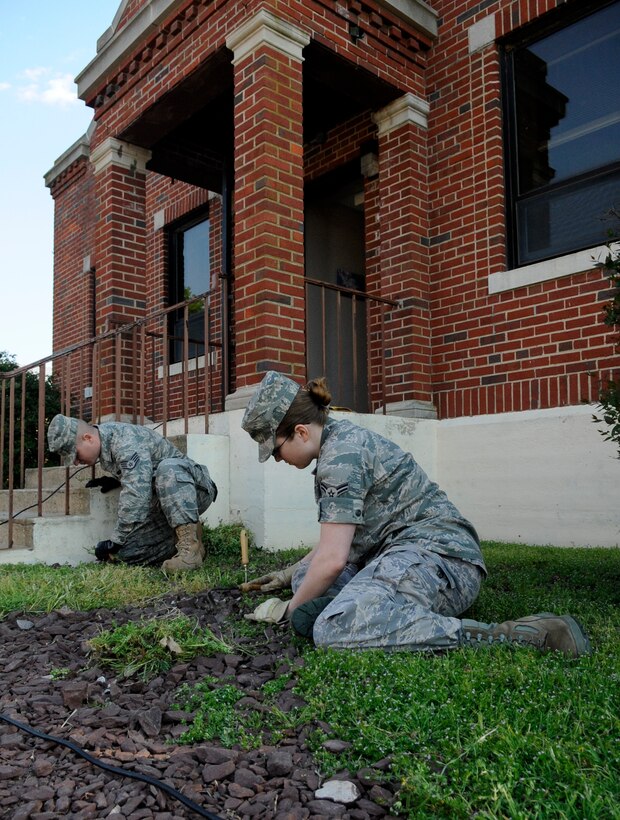 LANGLEY AIR FORCE BASE, Va. - Airman First Class Sarah Brice, 633d Air Base Wing Public Affairs broadcaster, and Staff Sgt. Barry Loo, 633ABW PA operational photography non commissioned officer in charge, pull weeds during Team Langley spring clean up week April 16. Team Langley spring clean up week April 12-16 was launched to restore the installation after a harsh winter. (U.S. Air Force photo/ Senior Airman Dana Hill)

