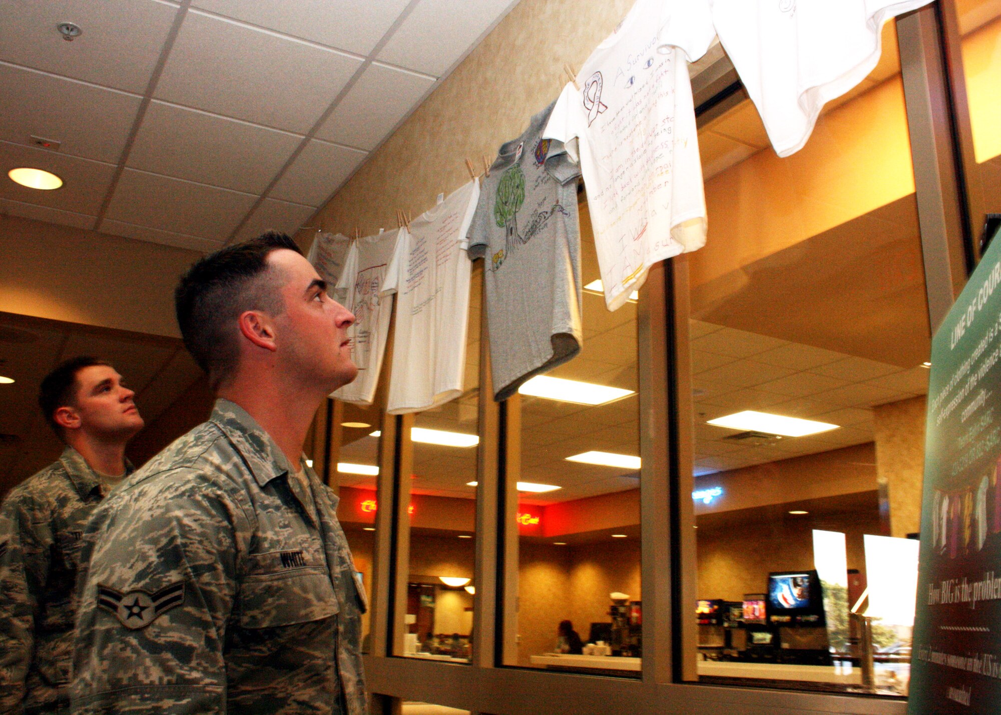 EGLIN AIR FORCE BASE, Fla. - Airmen 1st Class Timothy White and Patrick Thompson read the messages of the Line of Courage sexual assault awareness display at the Breeze dining facility April 16. The display features T-shirts created by both victims and victim advocates to tell their stories of sexual assault and the courage it took overcoming their situation. The Sexual Assault Prevention and Response office positioned these displays on base during April as part of sexual assault awareness month. May 20 will close out the special event planned for this year with a single service member beach bash at Post'l Point from 2 -5 p.m.(U.S. Air Force photo/ 2nd Lt Andrew Caulk)