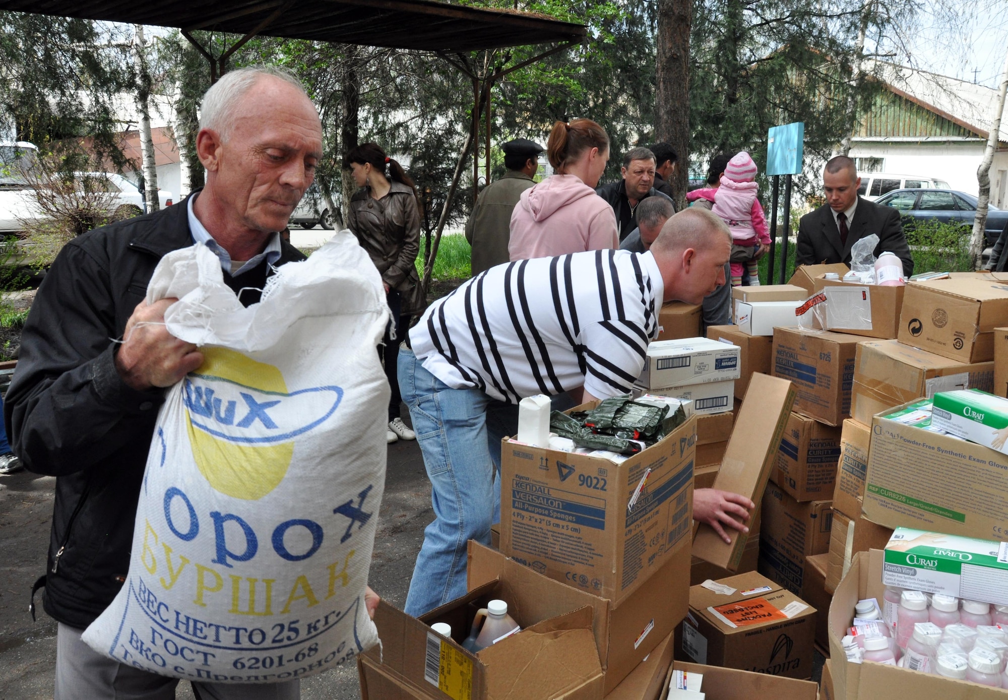 A Kyrgyz man helps Airmen from the Transit Center at Manas carry donated food and medical supplies for the National Hospital in Bishkek, Kyrgyzstan, April 15, 2010. This is a continuation of efforts started just a couple of days ago when 16,000lbs ? approximately $82,000 worth ? of supplies including bandages, sutures, antibiotics, and antiseptics, were delivered to the Transit Center at Manas from the U.S. Army Medical Material Center, Southwest Asia. A total of four hospitals were helped with these supplies.  (U.S. Air Force photo/Staff Sgt. Carolyn Viss)