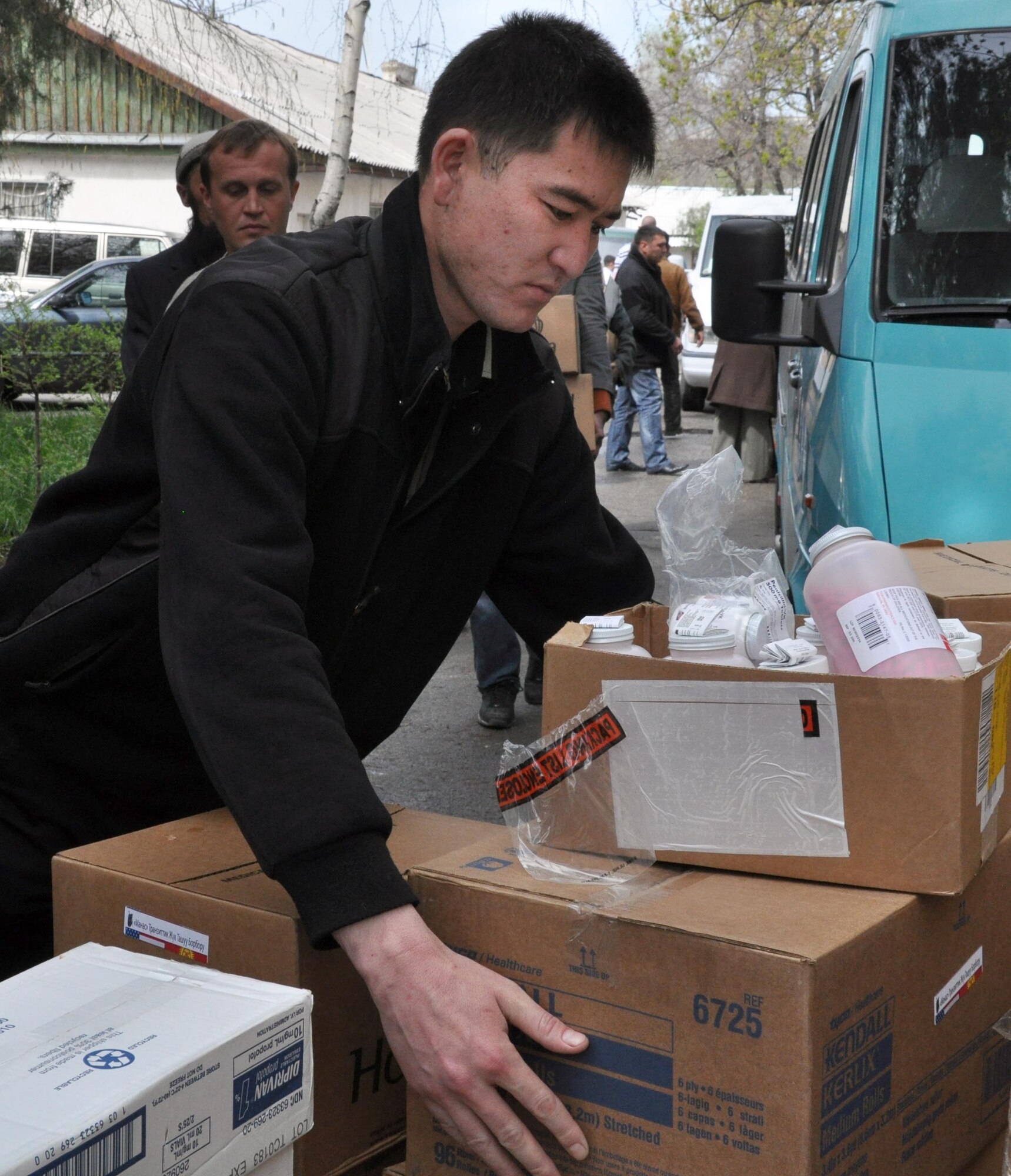 A Kyrgyz man helps Airmen from the Transit Center at Manas carry donated medical supplies for the National Hospital in Bishkek, Kyrgyzstan, April 15, 2010. This is a continuation of efforts started just a couple of days ago when 16,000lbs ? approximately $82,000 worth ? of supplies including bandages, sutures, antibiotics, and antiseptics, were delivered to the Transit Center at Manas from the U.S. Army Medical Material Center, Southwest Asia. A total of four hospitals were helped with these supplies.  (U.S. Air Force photo/Staff Sgt. Carolyn Viss)