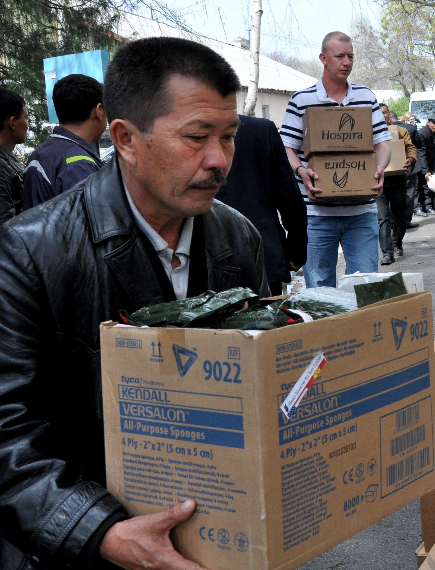 A Kyrgyz man helps Airmen from the Transit Center at Manas carry donated medical supplies for the National Hospital in Bishkek, Kyrgyzstan, April 15, 2010. This is a continuation of efforts started just a couple of days ago when 16,000lbs ? approximately $82,000 worth ? of supplies including bandages, sutures, antibiotics, and antiseptics, were delivered to the Transit Center at Manas from the U.S. Army Medical Material Center, Southwest Asia. A total of four hospitals were helped with these supplies.  (U.S. Air Force photo/Staff Sgt. Carolyn Viss)