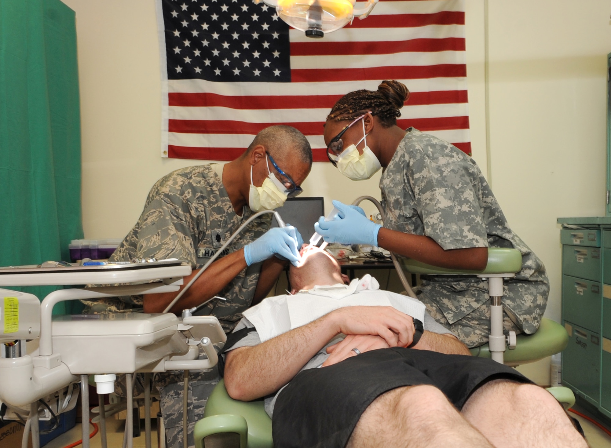 U.S. Air Force Lt. Col. Val Hagans, 506th Expeditionary Medical Squadron dentist and U.S. Army Spc. Laketa Bryant, 501st Brigade Support Battalion dental specialist, extract a patient’s wisdom teeth at Kirkuk Regional Air Base, Iraq on April 13, 2010.  Colonel Hagans is deployed from 96th Dental Squadron at Eglin AFB, Fla. (U.S. Air Force photo/Staff Sgt. Tabitha Kuykendall/Released)