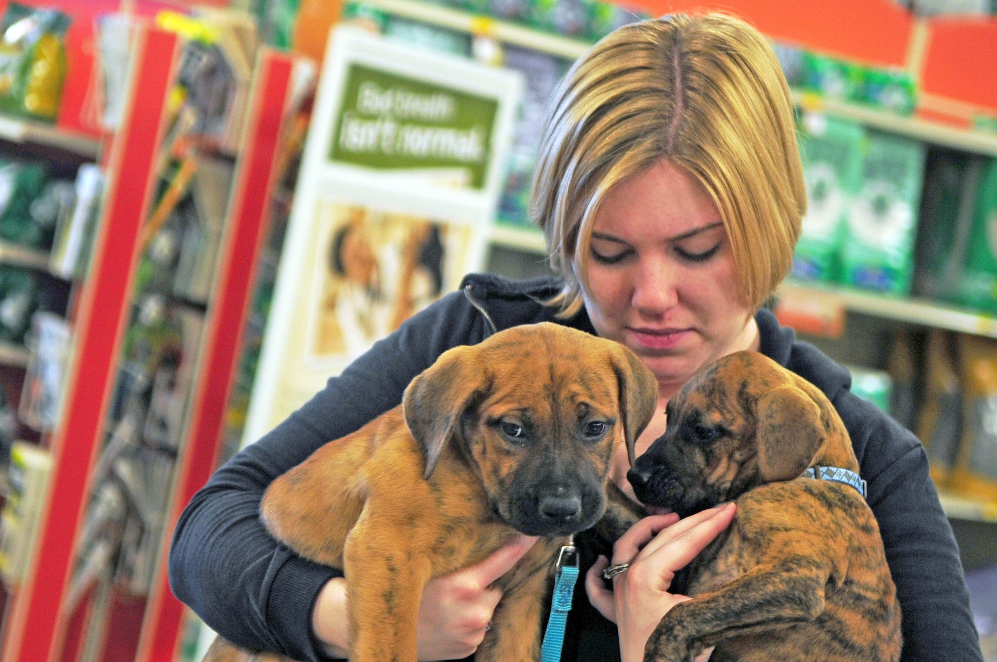 BOSSIER CITY, La. -- Staff Sgt. Samantha Plemmons, 2d Aerospace Medical Squadron, holds two puppies while volunteering for the Bossier City Animal Control's Hand-in-Paw adoption day at Petsmart April 10. Sergeant Plemmons is the co-founder for the nonprofit organization and dedicates nearly all of her Saturdays to the adoption day. (U.S. Air Force photo by Senior Airman Joanna M. Kresge)