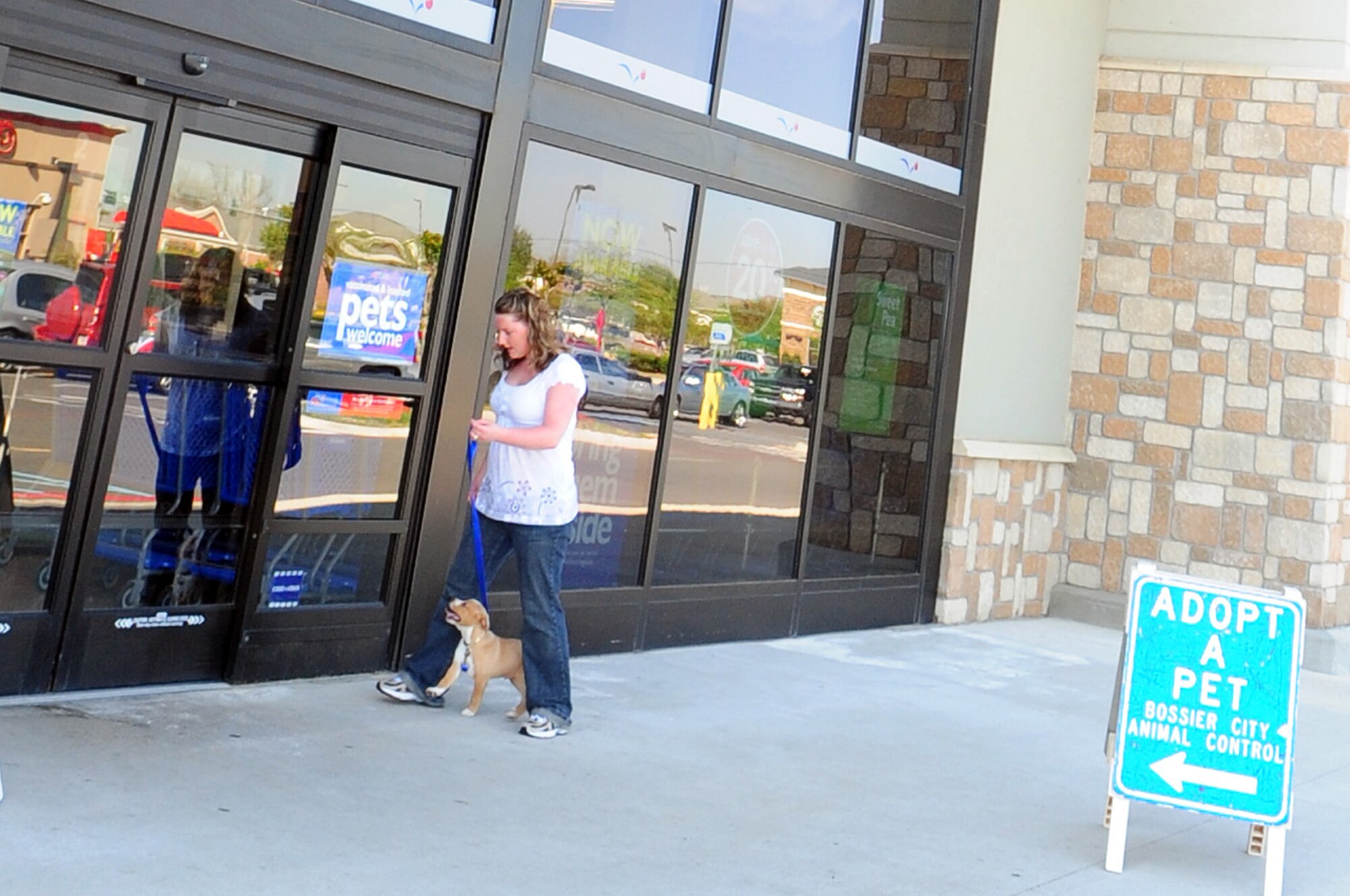 BOSSIER CITY, La. -- Senior Airman Shelia Titus, 2d Security Forces Squadron, walks a puppy into a local pet store April 10 while volunteering for the Bossier City Animal Control's Hand-in-Paw adoption day. Volunteers like Airman Titus help feed and clean the animals, transport them, walk the animals as needed and help customers complete the adoption process. (U.S. Air Force photo by Senior Airman Joanna M. Kresge)