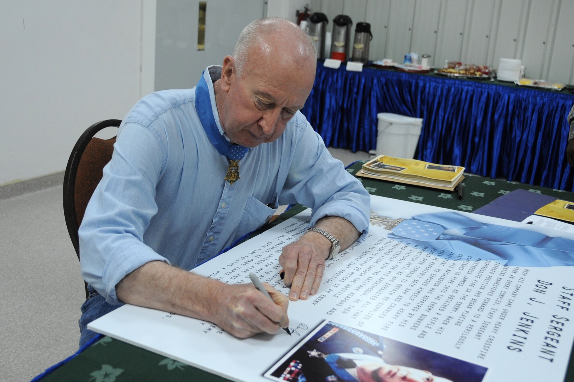 Former Army Staff Sgt. Don. J. Jenkins, Medal of Honor recipient, autographs a poster for display at the 380th Air Expeditionary Wing at a non-disclosed location in Southwest Asia on April 12, 2010. Sergeant Jenkins earned his Medal of Honor on Ja. 6, 1969, when he was a private first class serving in Vietnam. His citation states that Sergeant Jenkins' "extraordinary valor, dedication, and indomitable spirit inspired his fellow soldiers to repilse the determined enemy attack and ultimately defeat the larger force." Sergeant Jenkins and another Medal of Honor winner, retired Lt. Col. Alfred V. Rascon, visited the 380th Air Expeditionary Wing as part of a tour with Armed Forces Entertainment. The dining in was held in their honor. (U.S. Air Force Photo/Senior Airman Jenifer H. Calhounl/Released) 
